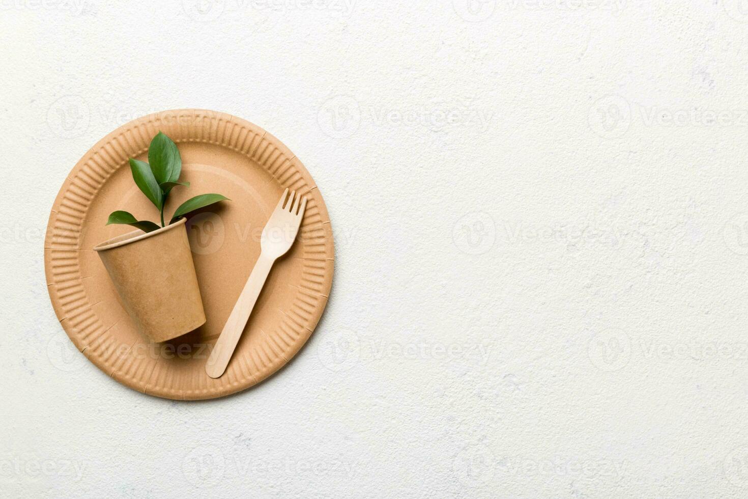 set of empty reusable disposable eco-friendly plates, cups, utensils on light white colored table background. top view. Biodegradable craft dishes. Recycling concept. Close-up photo