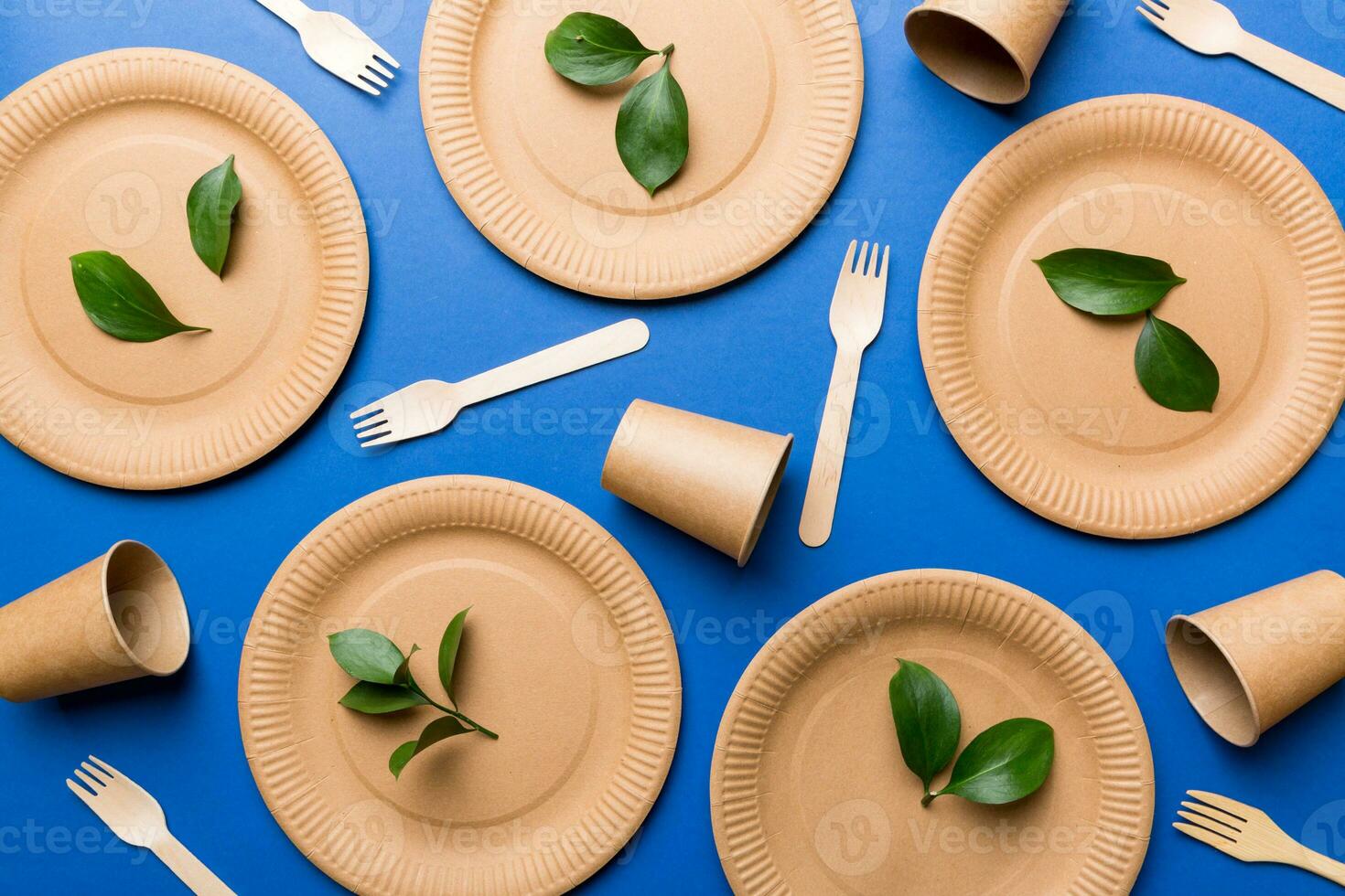 set of empty reusable disposable eco-friendly plates, cups, utensils on light white colored table background. top view. Biodegradable craft dishes. Recycling concept. Close-up photo