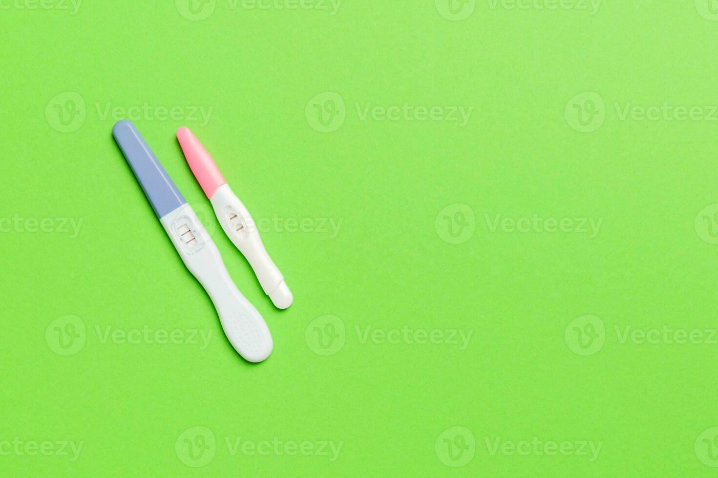 Colored Pregnancy test on colored background, top view with copy space photo