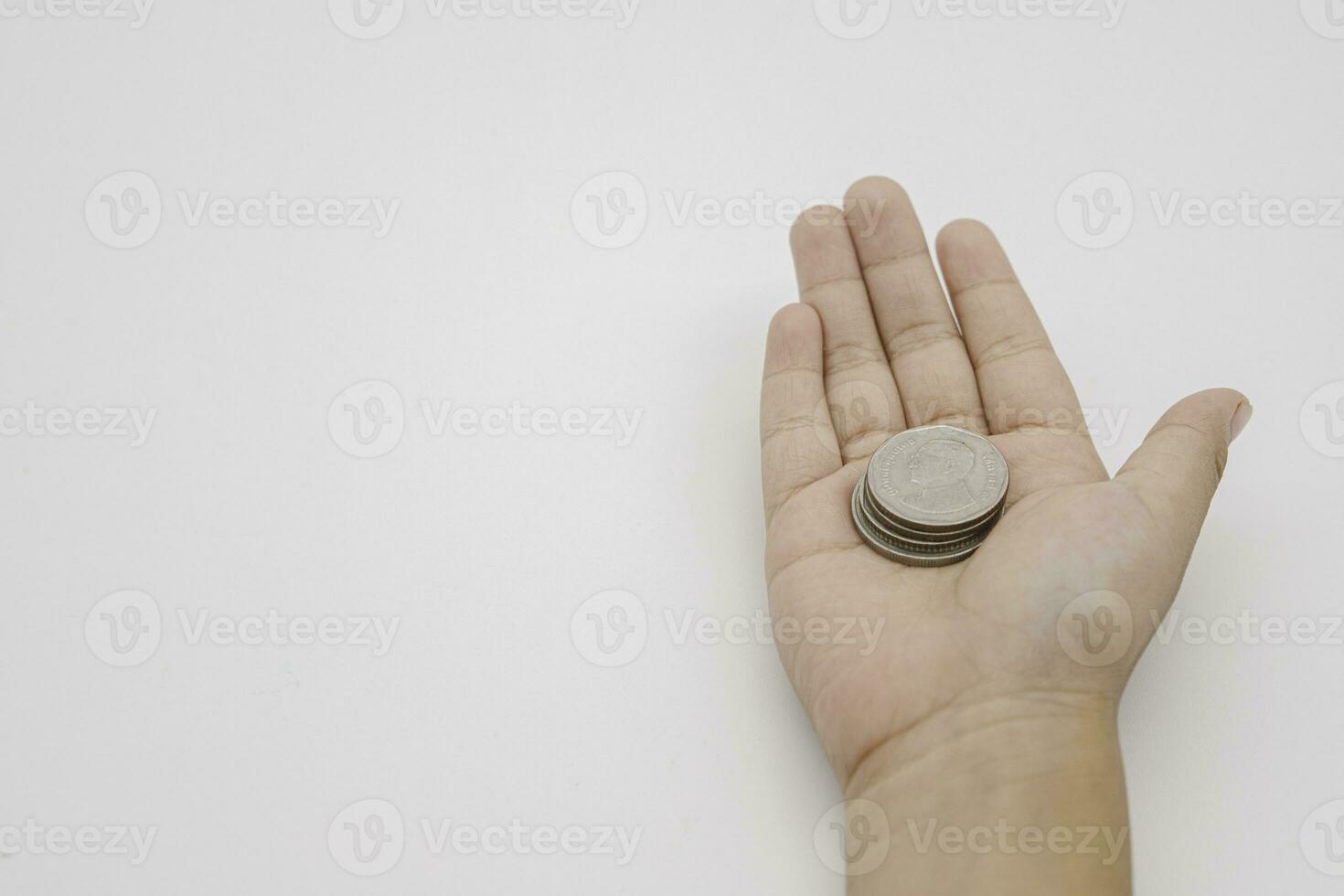 Child hand holding coin on white background, save money for prepare in the future. Copy space for your text photo