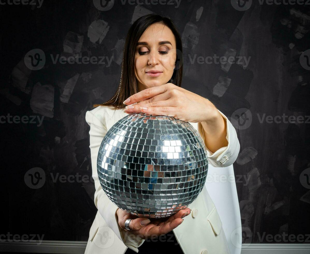 retrato de un mujer participación un plata disco pelota. tomado en un foto estudio.