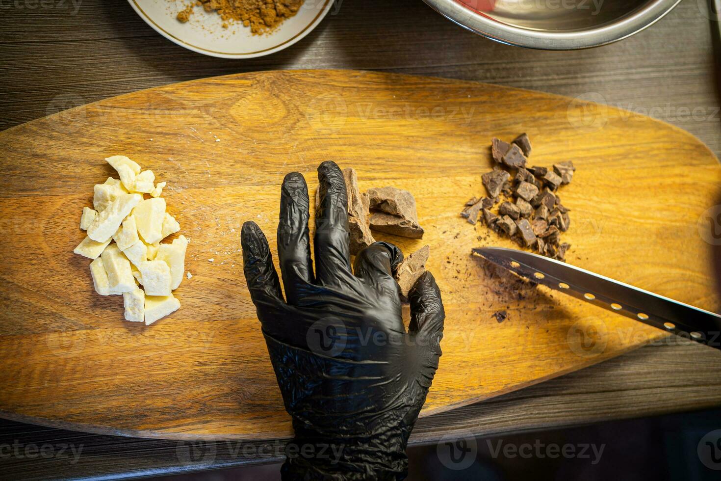 Woman cooking tasty melted chocolate on table in kitchen. photo