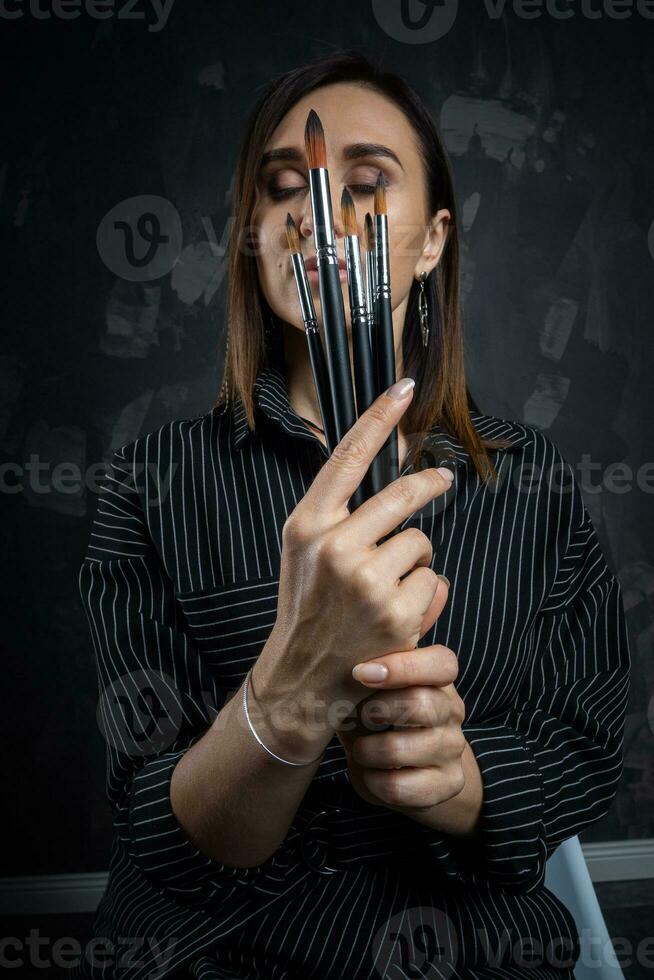 Portrait of a female artist, with brushes in her hands. photo