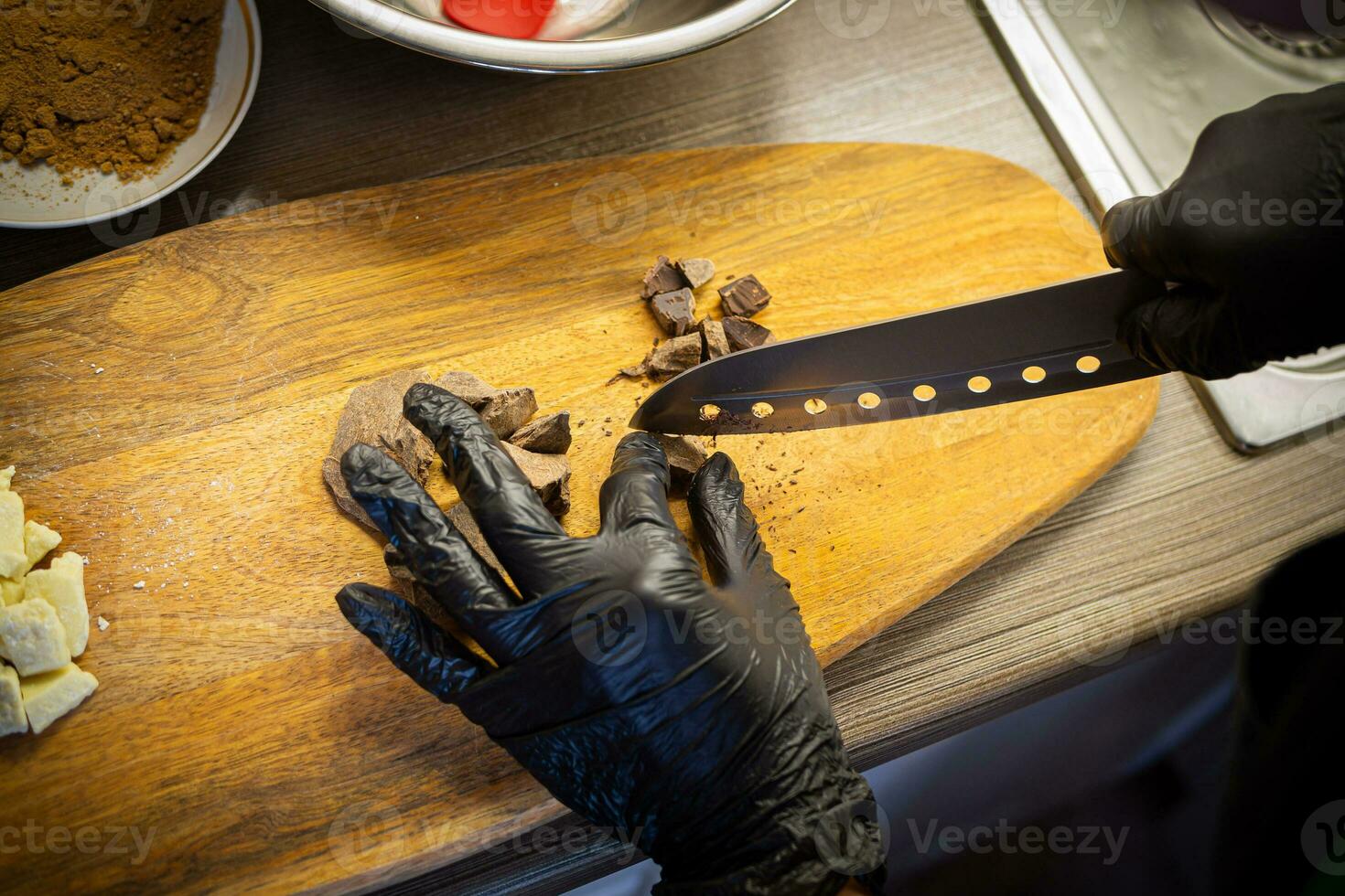 Woman cooking tasty melted chocolate on table in kitchen. photo