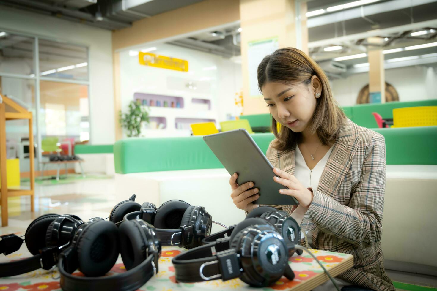 Beautiful asian businesswoman is sitting and  presses tablet to photo