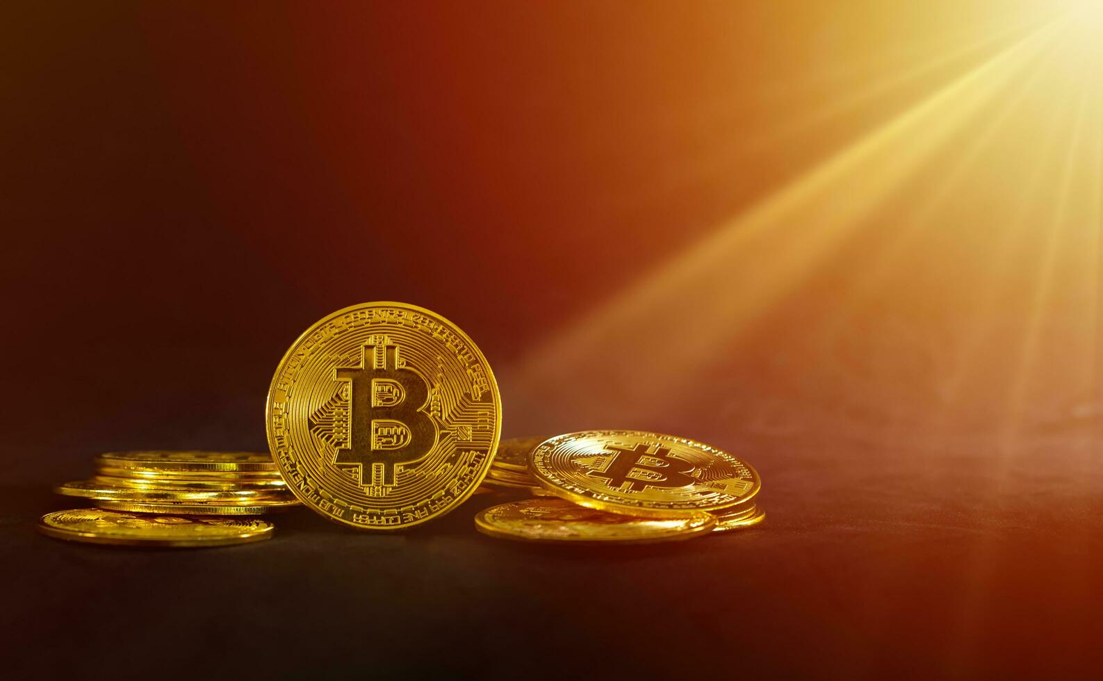 Golden bitcoin in the middle of pile, Bitcoin with sun rays on black background. Crypto currency concept. photo