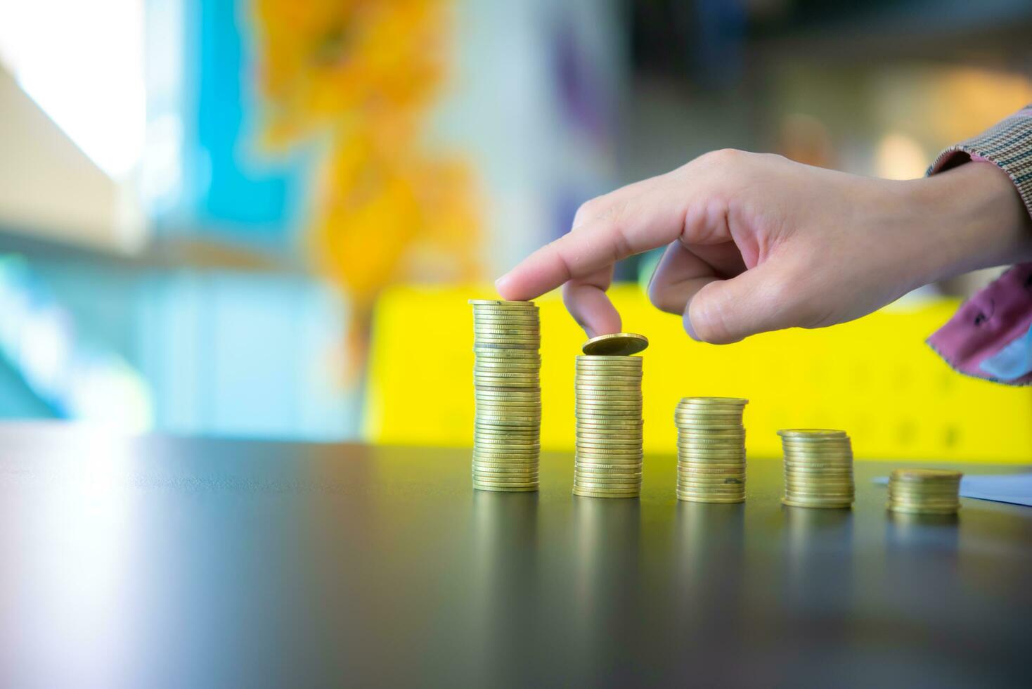 Business woman touching the first and second pile of coins from the left on black desk, Digital money concept, Finance and management concept, Business for future concept, Finance and investment. photo