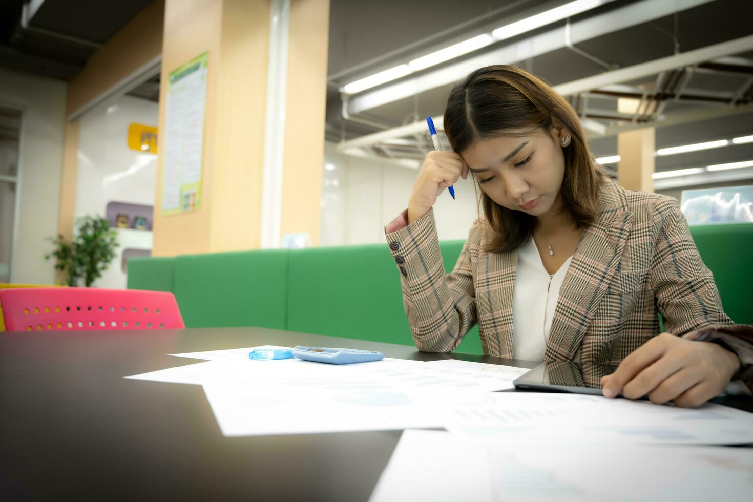 hermosa asiático mujer de negocios es estresado acerca de un relacionado con documentos problema en el compañía. foto