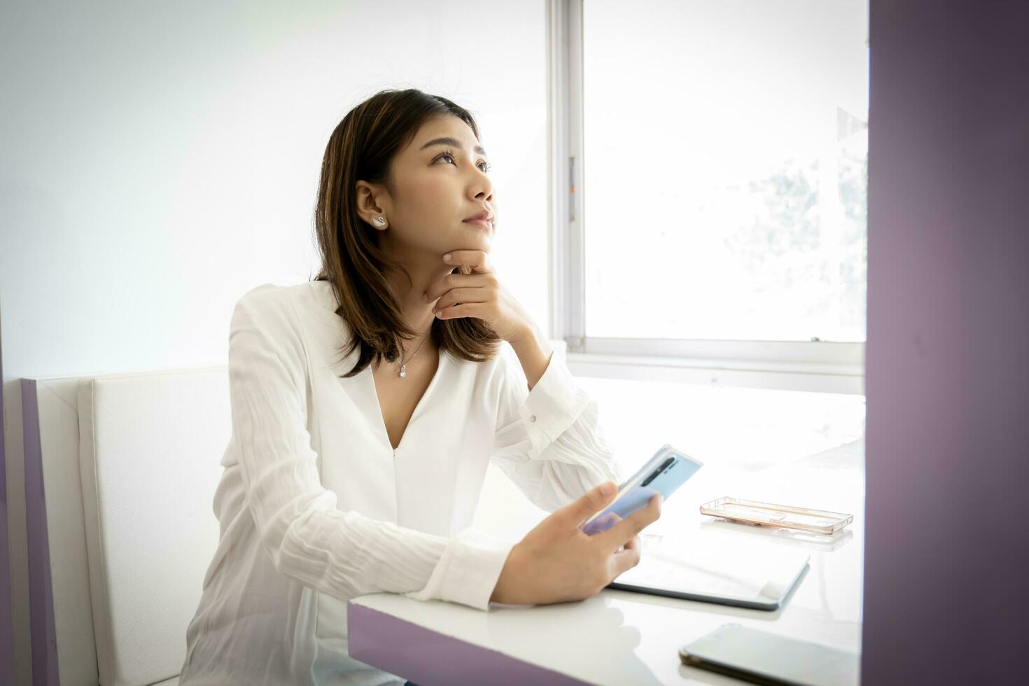 Beautiful asian businesswoman is coming up with a project to present to her boss on her desk at her office. photo