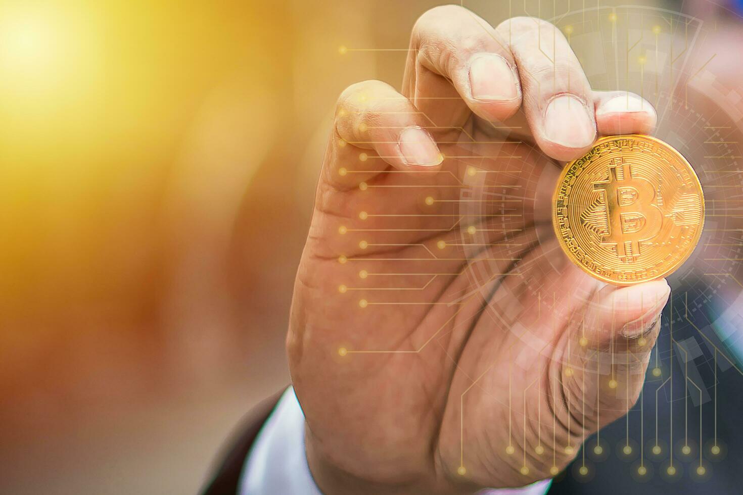 Golden bitcoin in businessman hand, bokeh, morning light  background, coin currency in future. photo