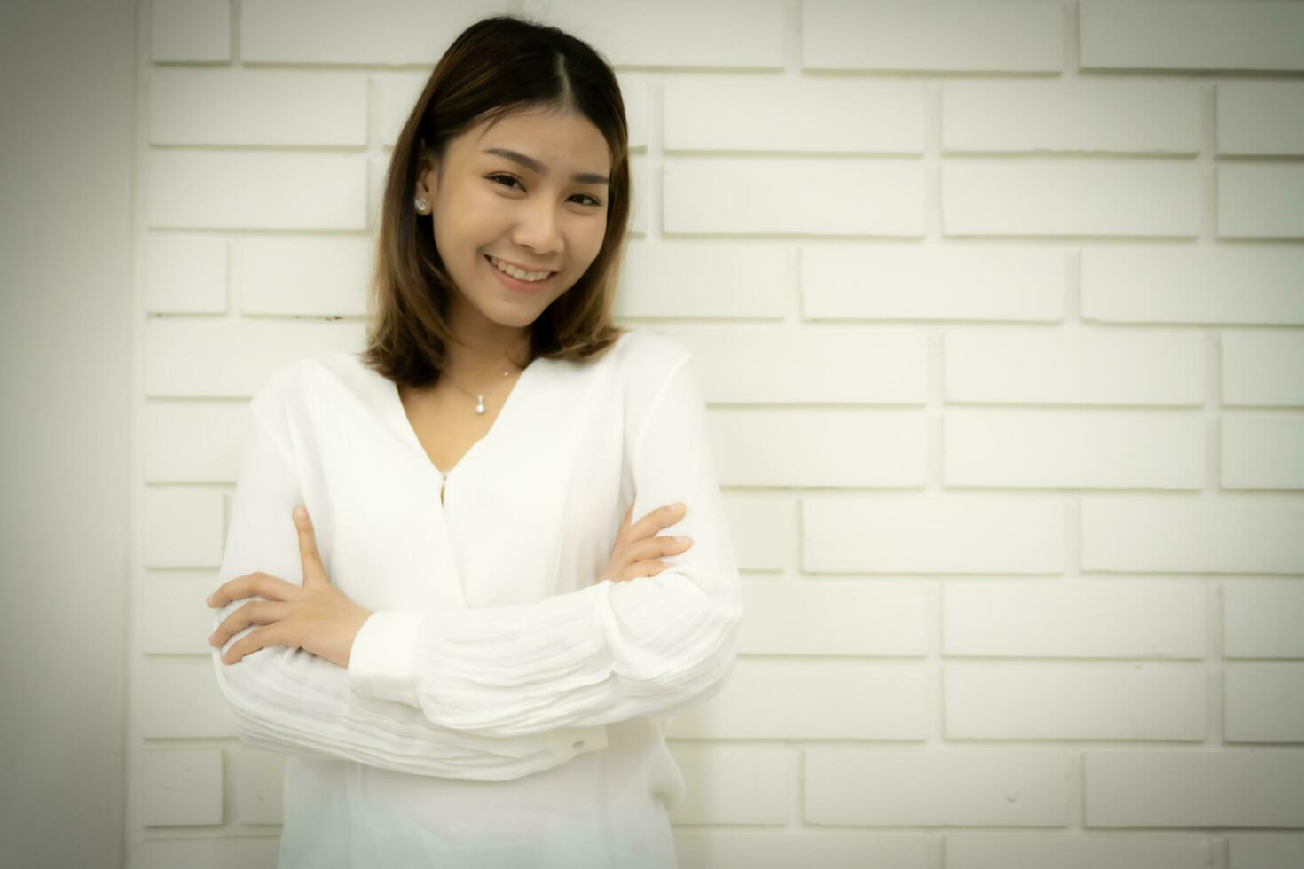 Portrait of a beautiful business woman in a close-up shot is standing with arms crossed and looking at the camera with smile on her face. photo