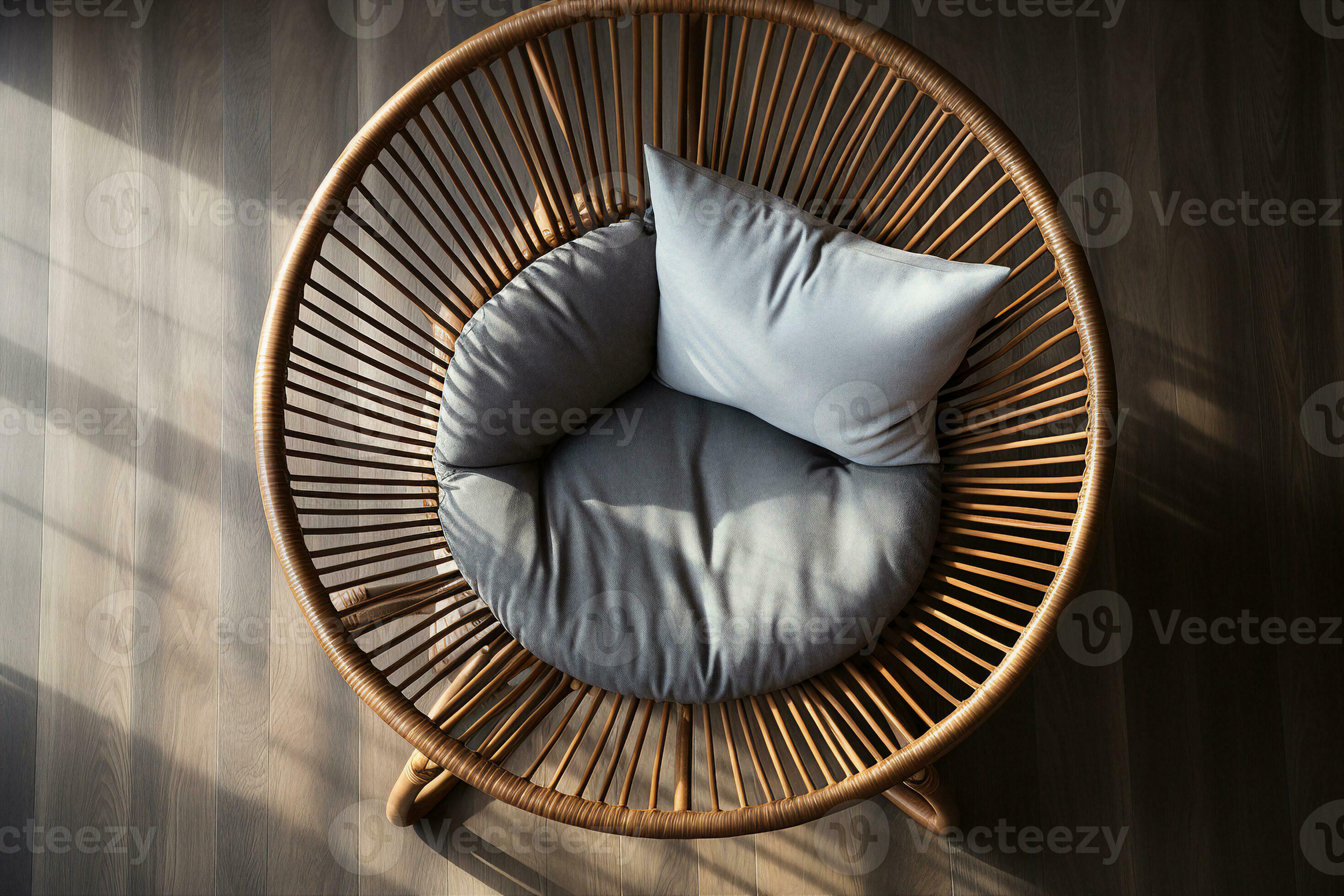 A round wicker rattan chair with a fluffy white pillow in front of a