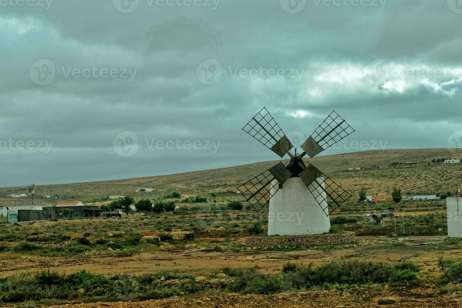 empty mysterious mountainous landscape from the center of the Canary Island Spanish Fuerteventura with a cloudy sky and original windmills photo