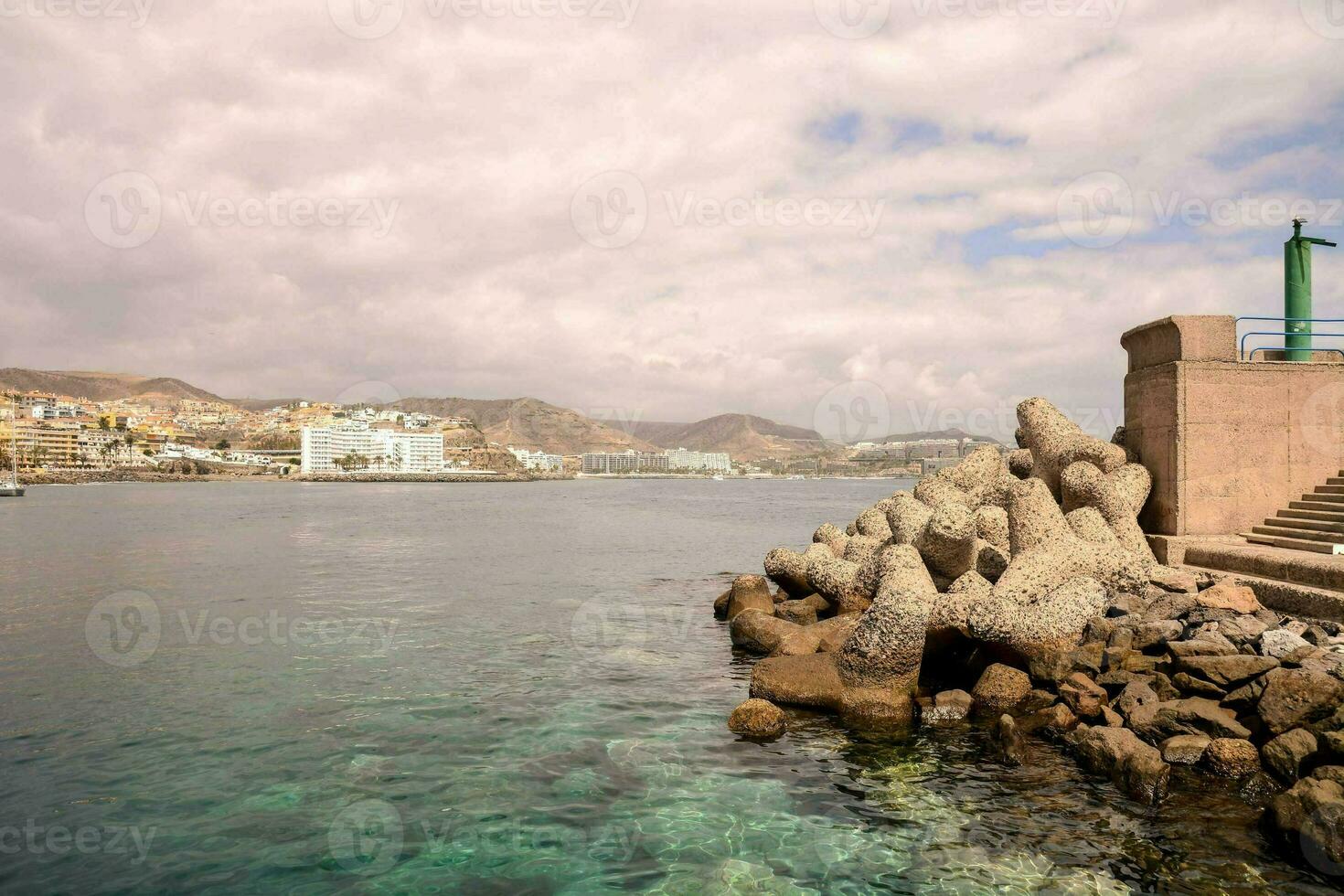 a view of the sea and a city from a rocky shore photo