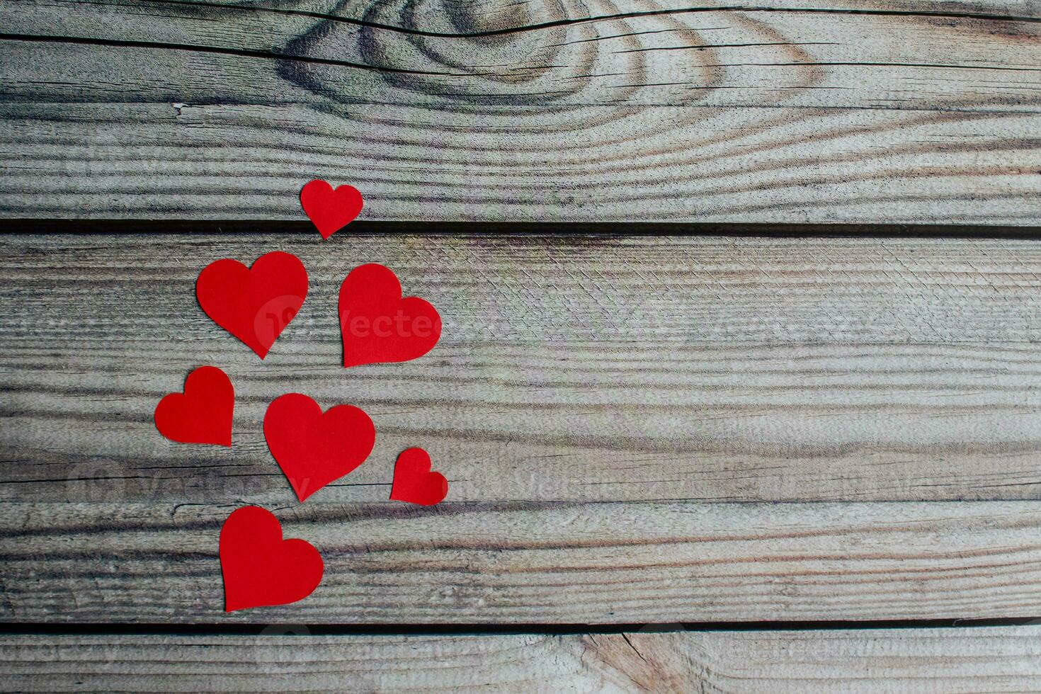 San Valentín día, pequeño y grande rojo corazón símbolo hermosa metido en un de madera mesa. tomar un de cerca y Seleccione enfocar, Copiar espacio en Derecha para diseño y texto. borroso antecedentes. foto