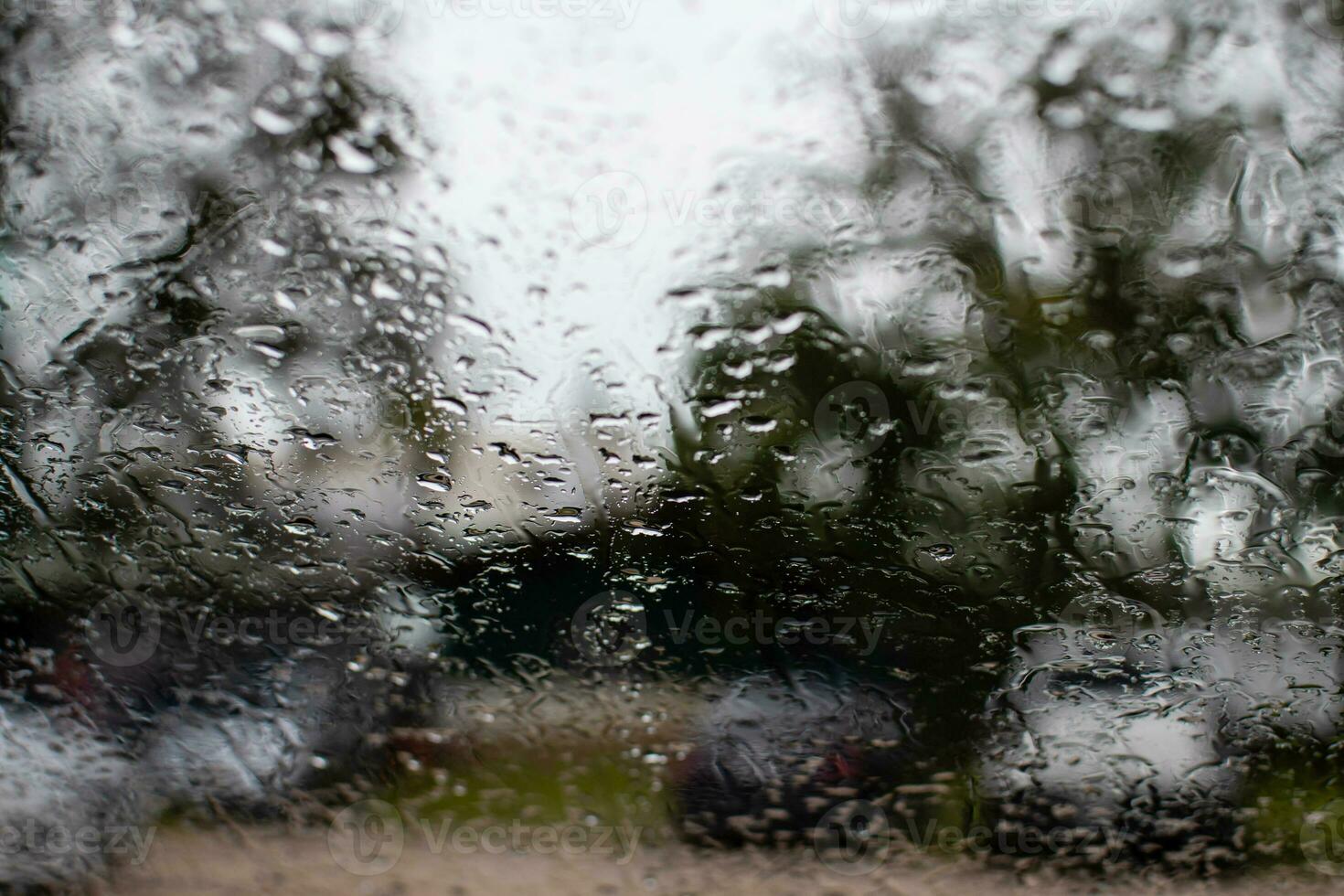 Bright water on the car window, after rain evening, in the parking, take closeup photography, color black and gray background blurred and landscape. photo
