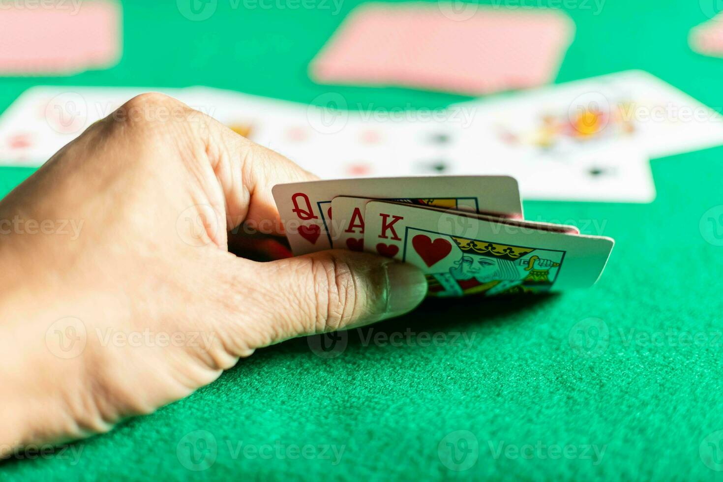 primer plano, la mano del hombre sosteniendo cartas en el juego de rummy también llamado juego de cartas. fondo borroso foto