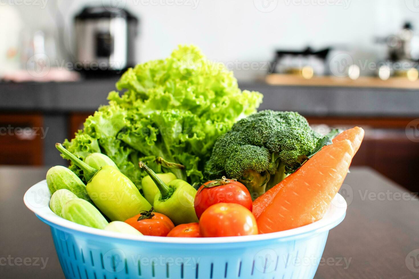 Close-up, Cucumbers, lettuce, carrots in blue containers were placed on a wooden table. These vegetables are for making healthy meals. Blurred background. photo