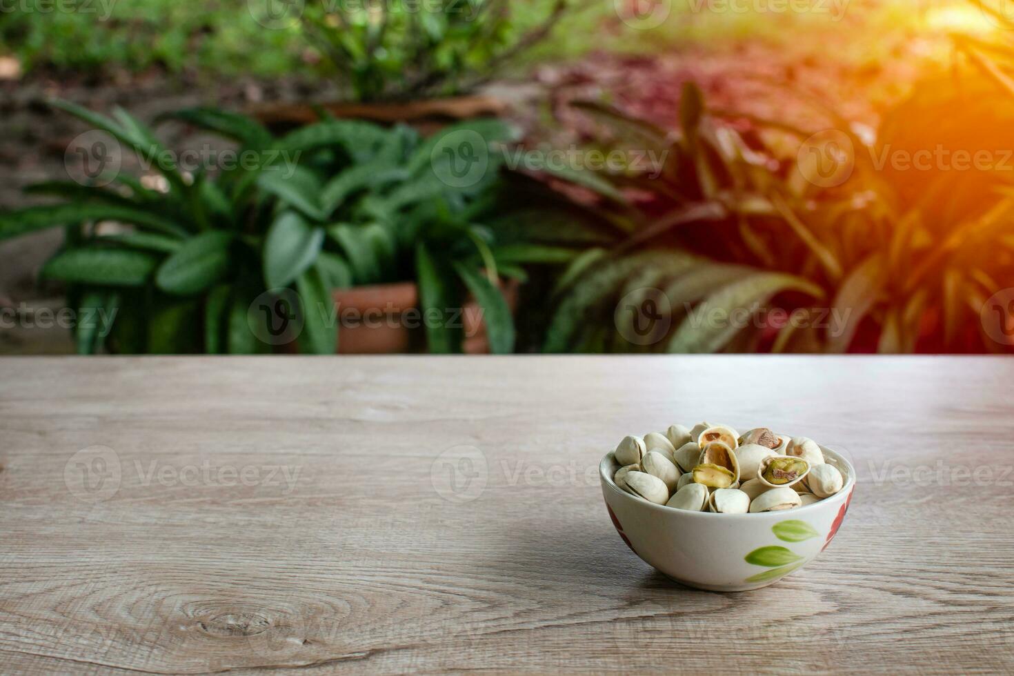 nuts in a cup on an old wood grain table right corner and take a closeup and slope view, left copy space for text input, the photo is a landscape, and the background blurred