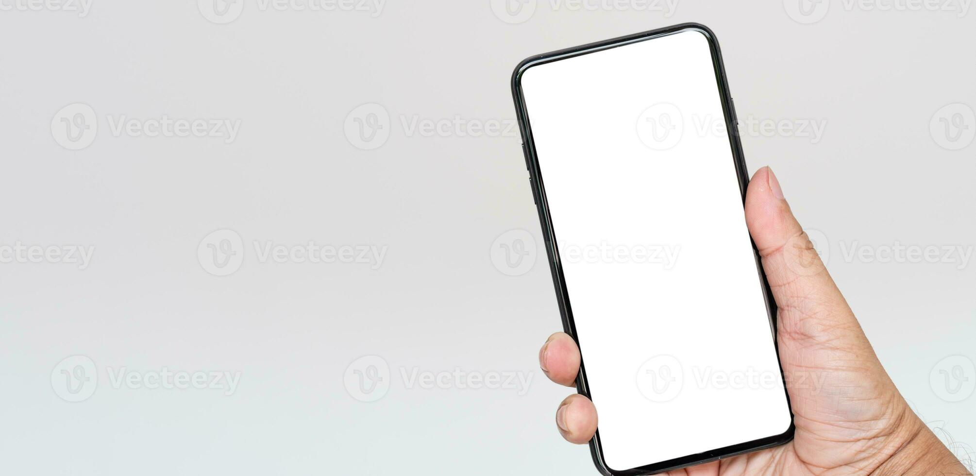 Close-up, lonely, selective focus hand holding a smartphone with a white screen and on a white background, concept, technology, communication, online, internet photo