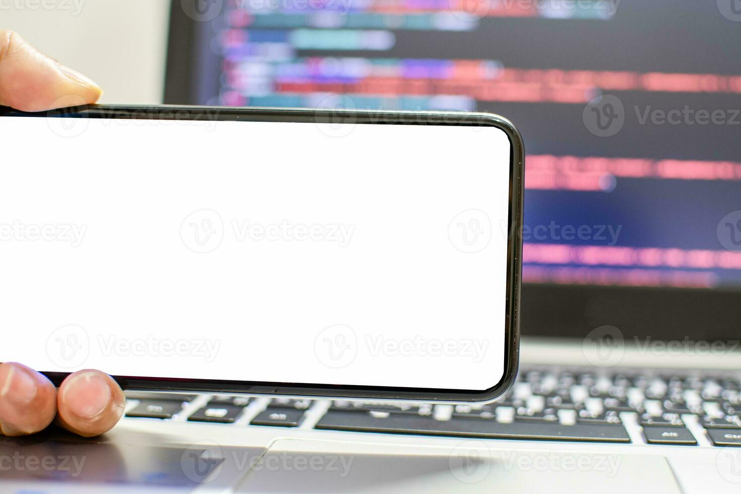 The developer wants to run an app on the smartphone device after coding from the IDE, the hand holding smartphone device the white screen, Take a close-up shot, blurred background, and clipping paths. photo