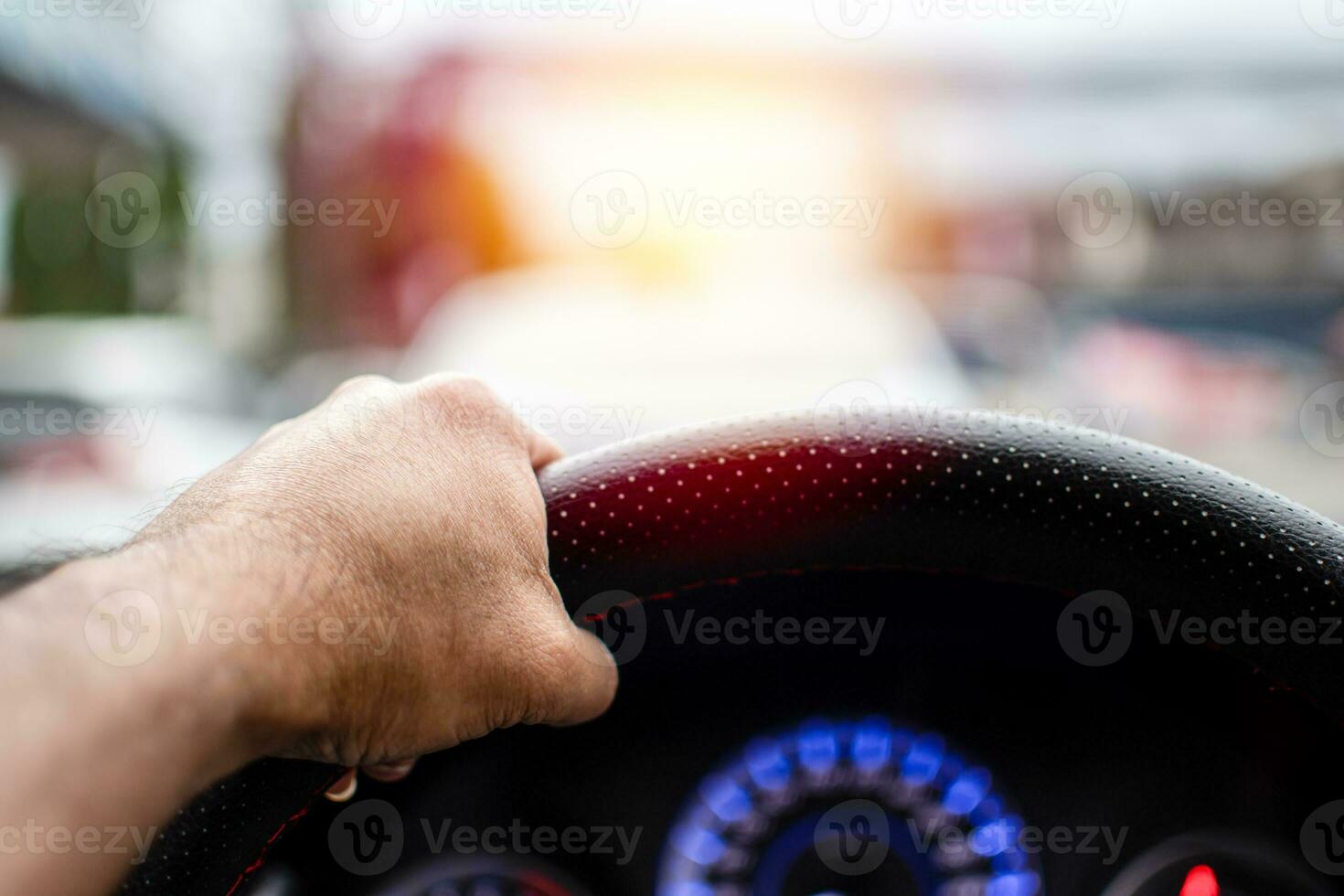 A man driving a left hand to hold the steering wheel To control the car carefully While traffic congestion, has copyspace on top for input text, take a close-up shot, blurred background photo