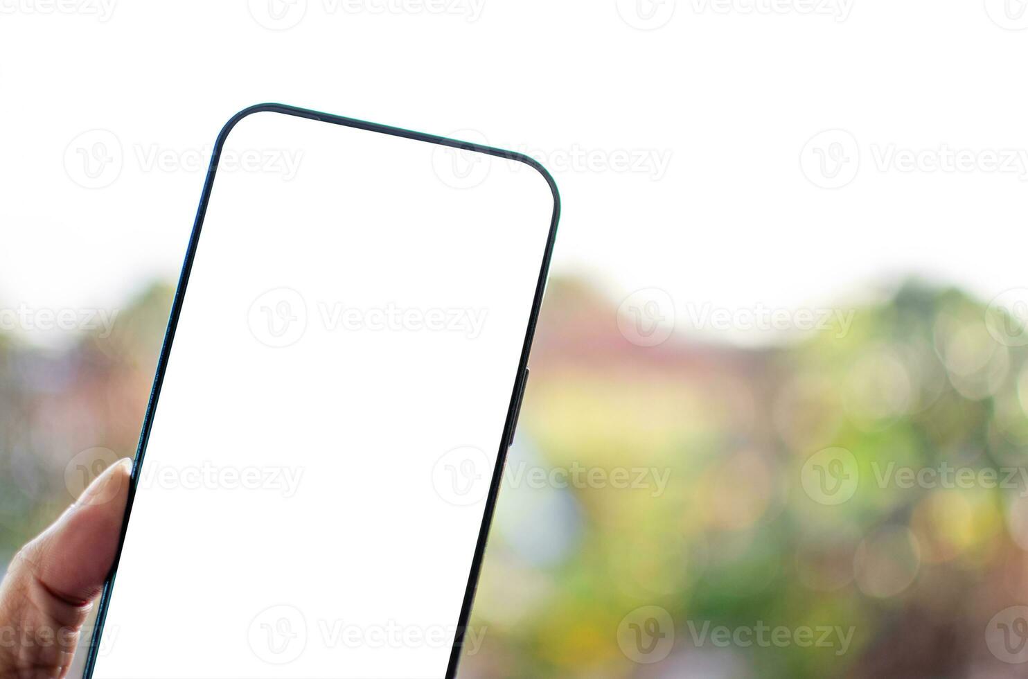 Smartphone handle, white, and a blank screen for design and message. Concept of new phone technology Takes closeup with a blurred background. The screen of the mobile device is blank, clipping pat photo