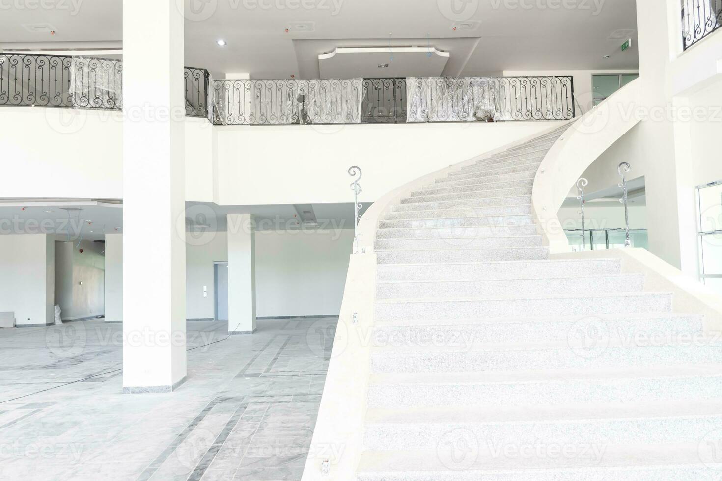 Residential space nobody. Stairs upstairs of the under construction office. The space inside the building is empty. The upper floor has a leak proof rail. photo