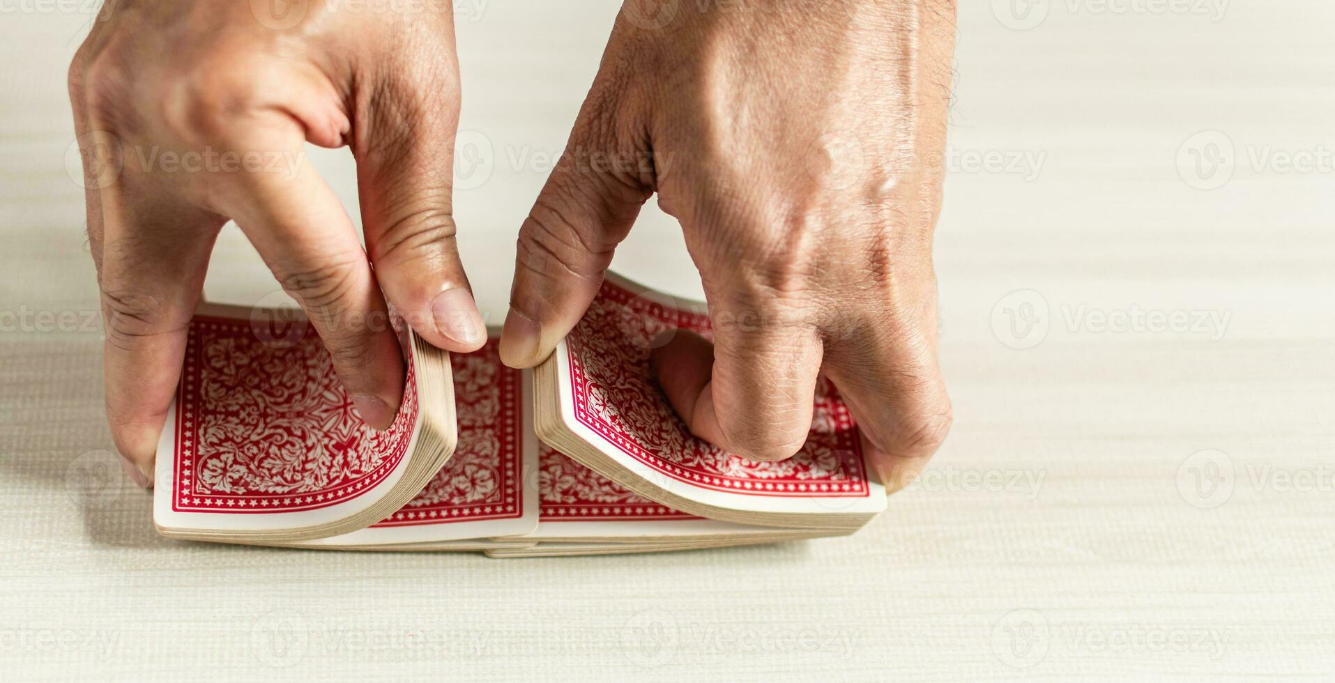 Close-up of a man holding cards shuffling playing rummy on holiday, party, birthday, selective focus. Copy the right area for design or text, blurred background. photo