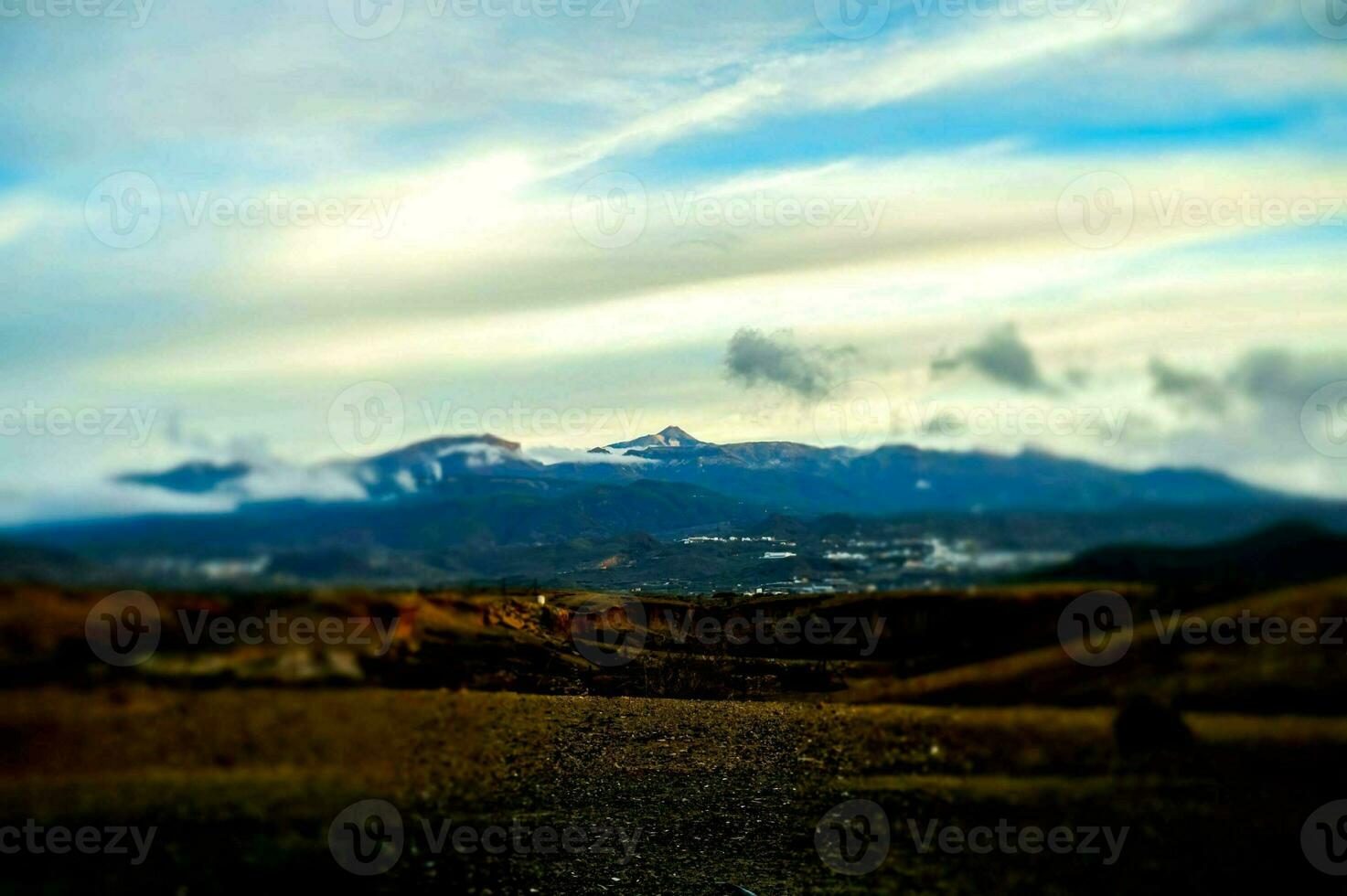 a view of the mountains from a dirt road photo