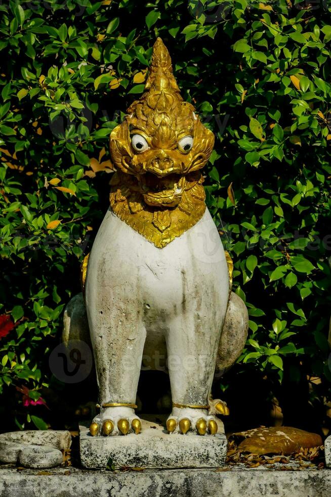 statue of a lion with gold and white paint photo