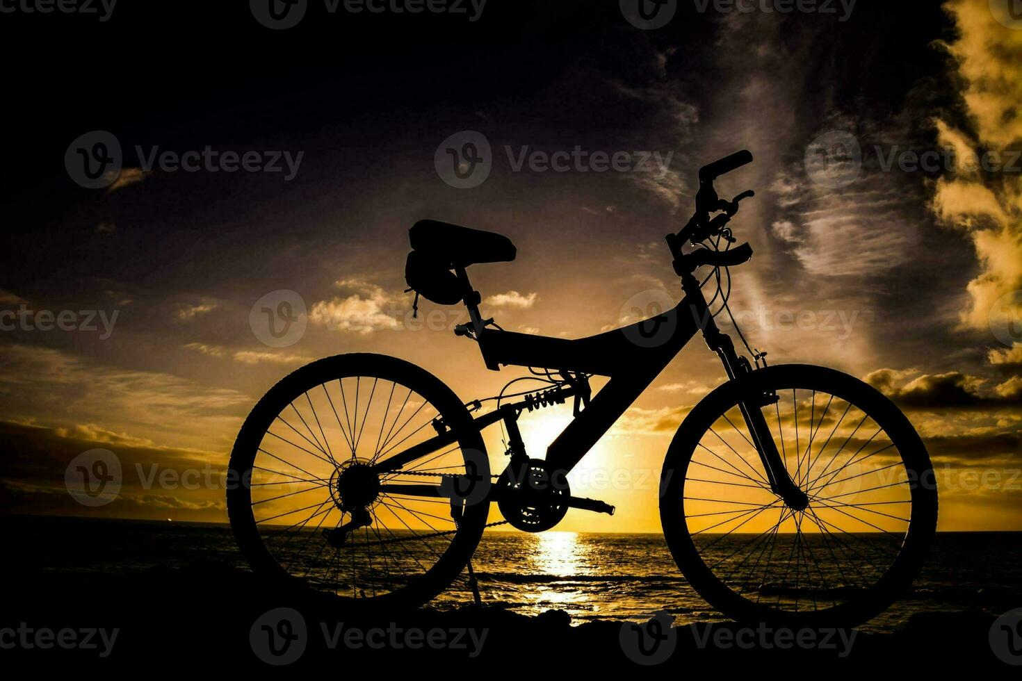 a bicycle is silhouetted against the sunset at the beach photo