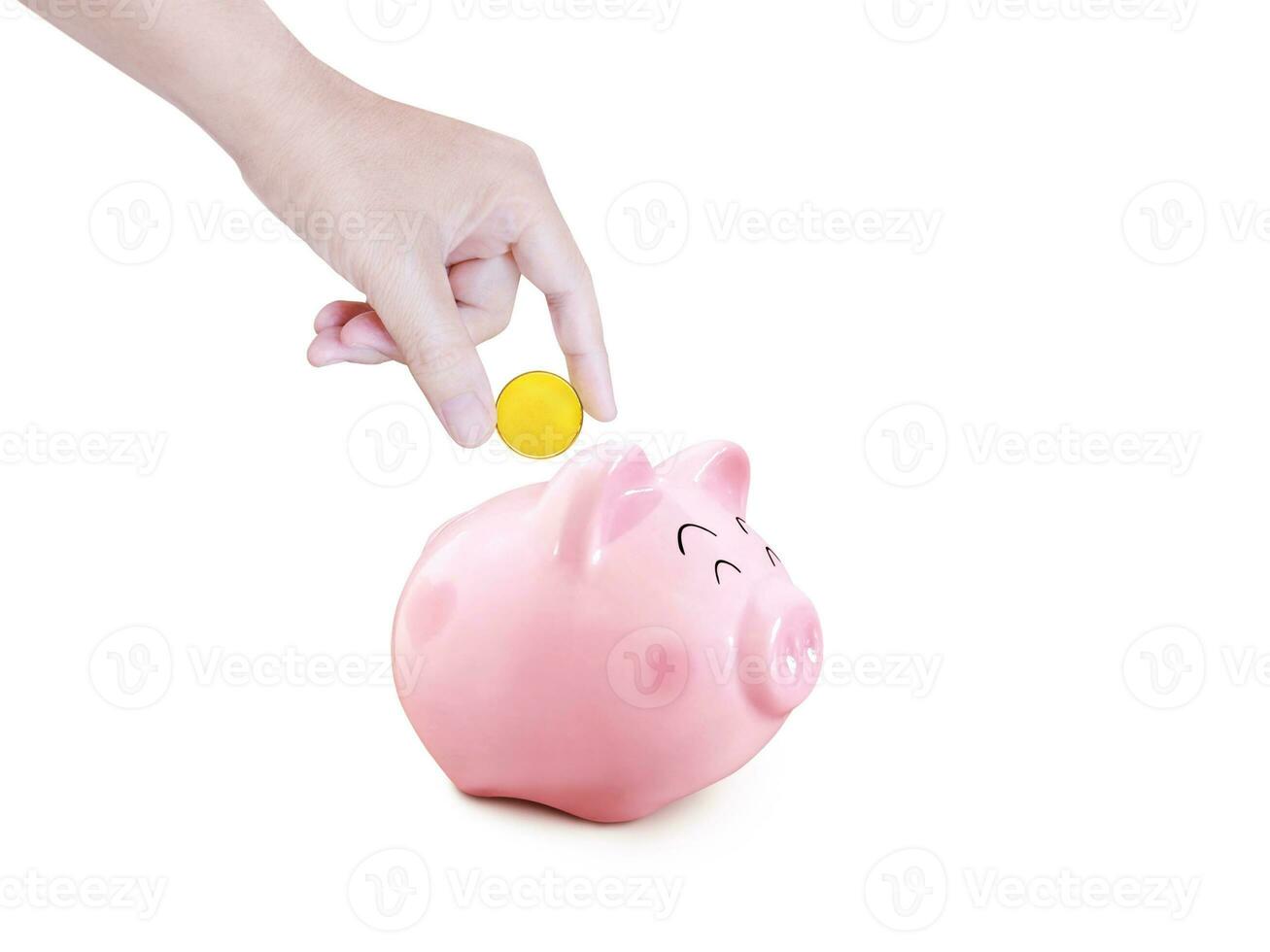 Hand puts gold coins into a piggy bank on a white background. photo