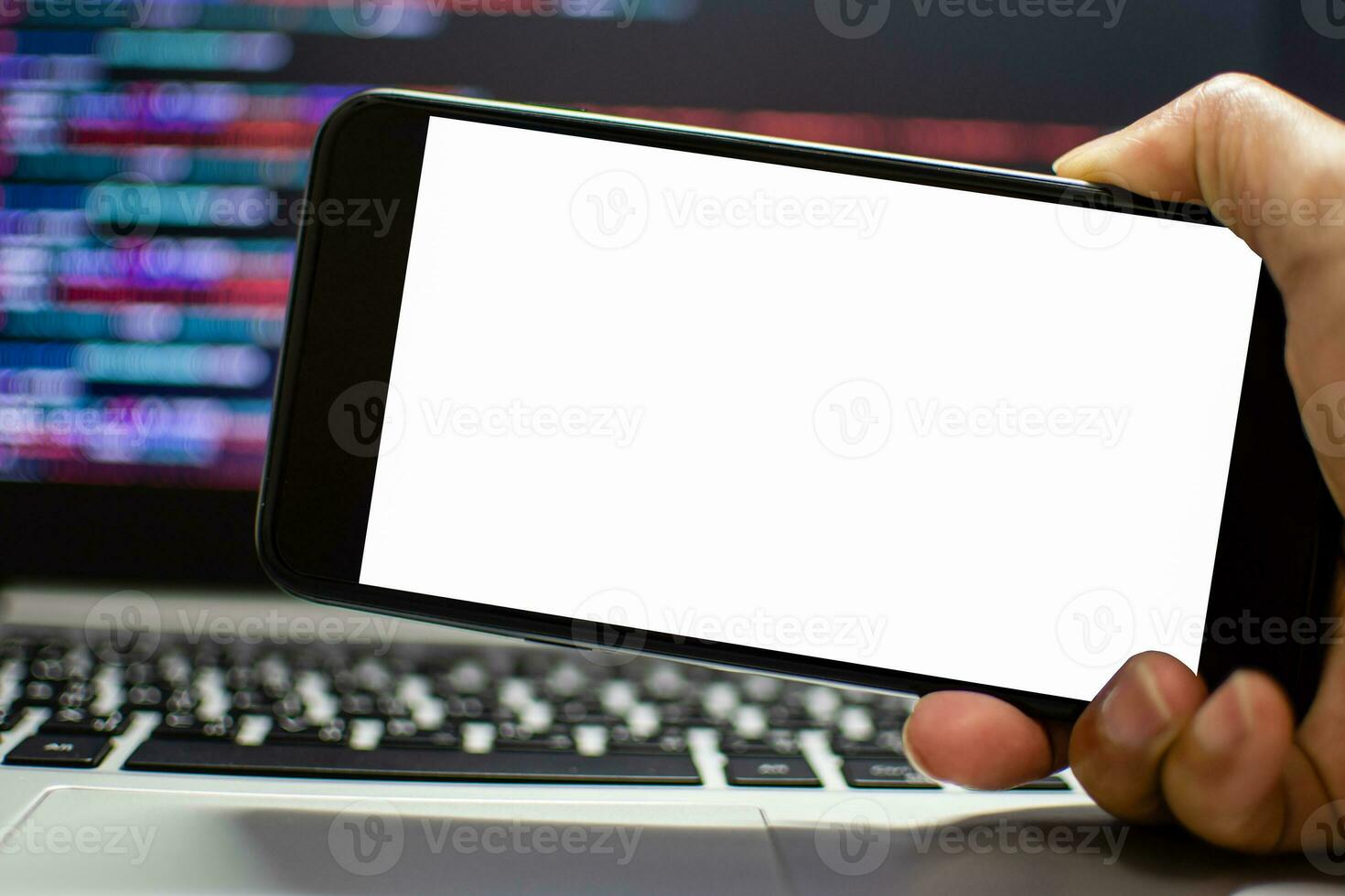 The developer wants to run an app on the smartphone device after coding from the IDE, the hand holding smartphone device the white screen, Take a close-up shot, blurred background, and clipping paths. photo