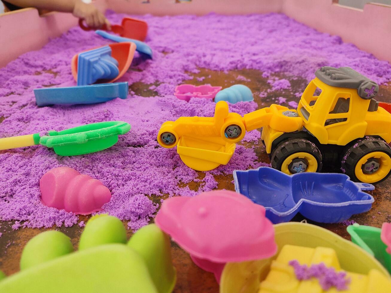 Plastic toy on kinetic sand pool photo