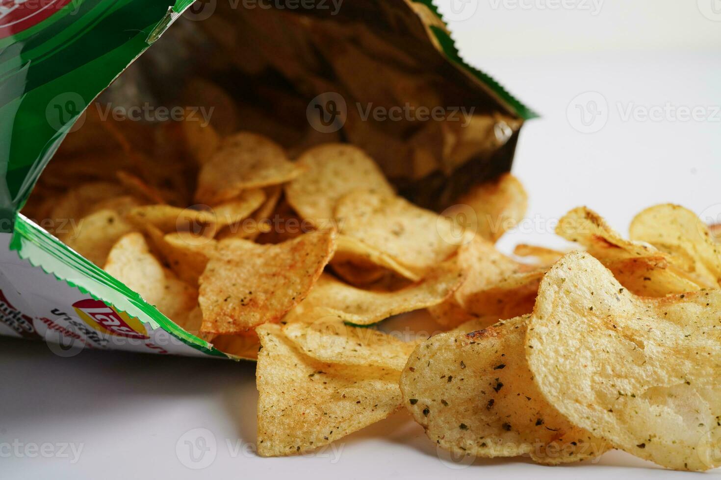 Bangkok, Thailand - May 15, 2022 Potato chips in open bag, delicious BBQ seasoning spicy for crips, thin slice deep fried snack fast food in open bag. photo