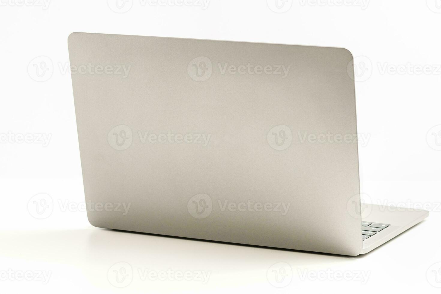 The back of the laptop is blank, placed on a white desk in an office, and nobody. Technology work concept, smartphone, notebook, internet, left side copy space, close up, white background, and blurred photo