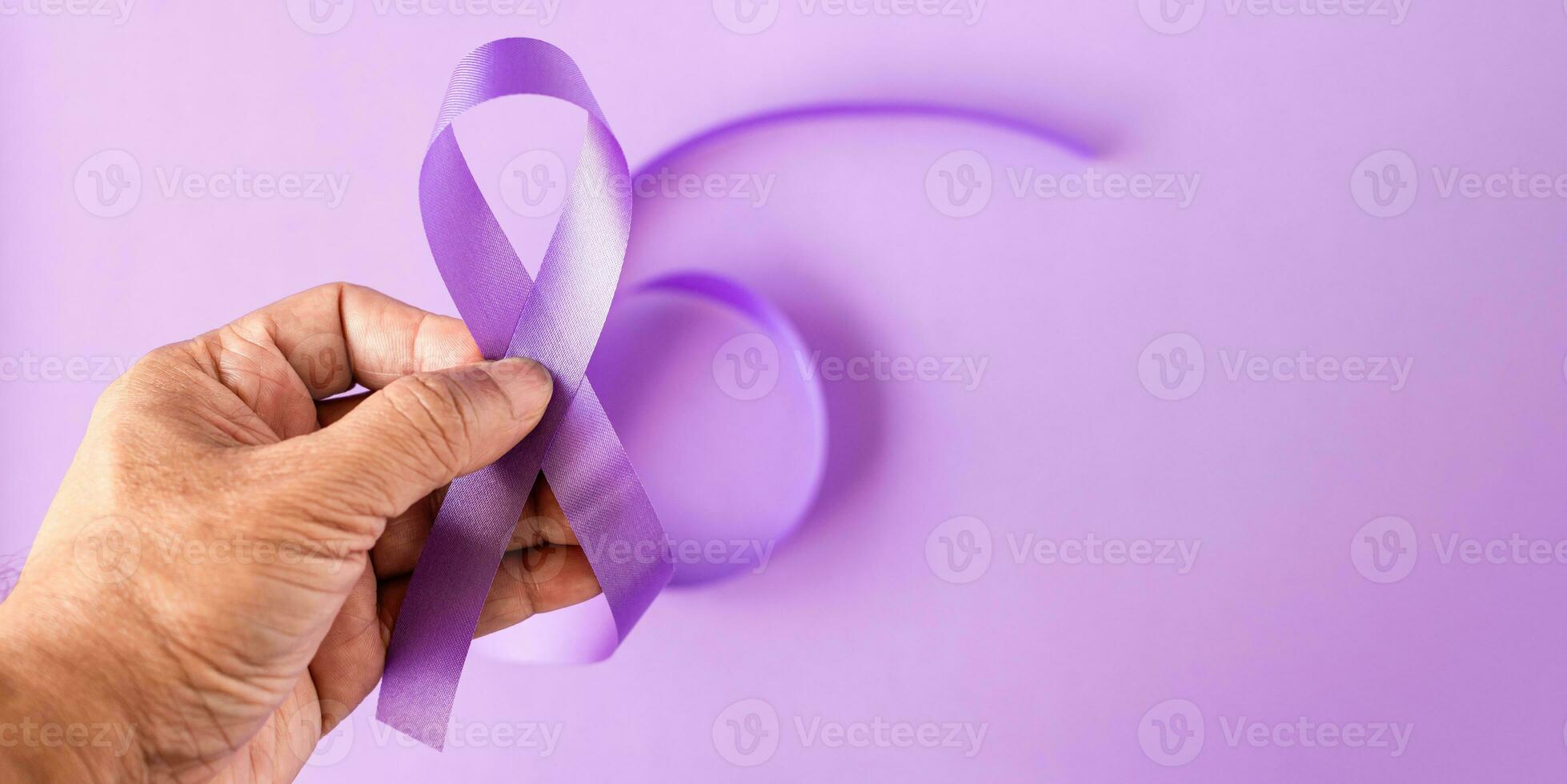 International Overdose Awareness Day. Hand holds purple ribbon on the purple background photo