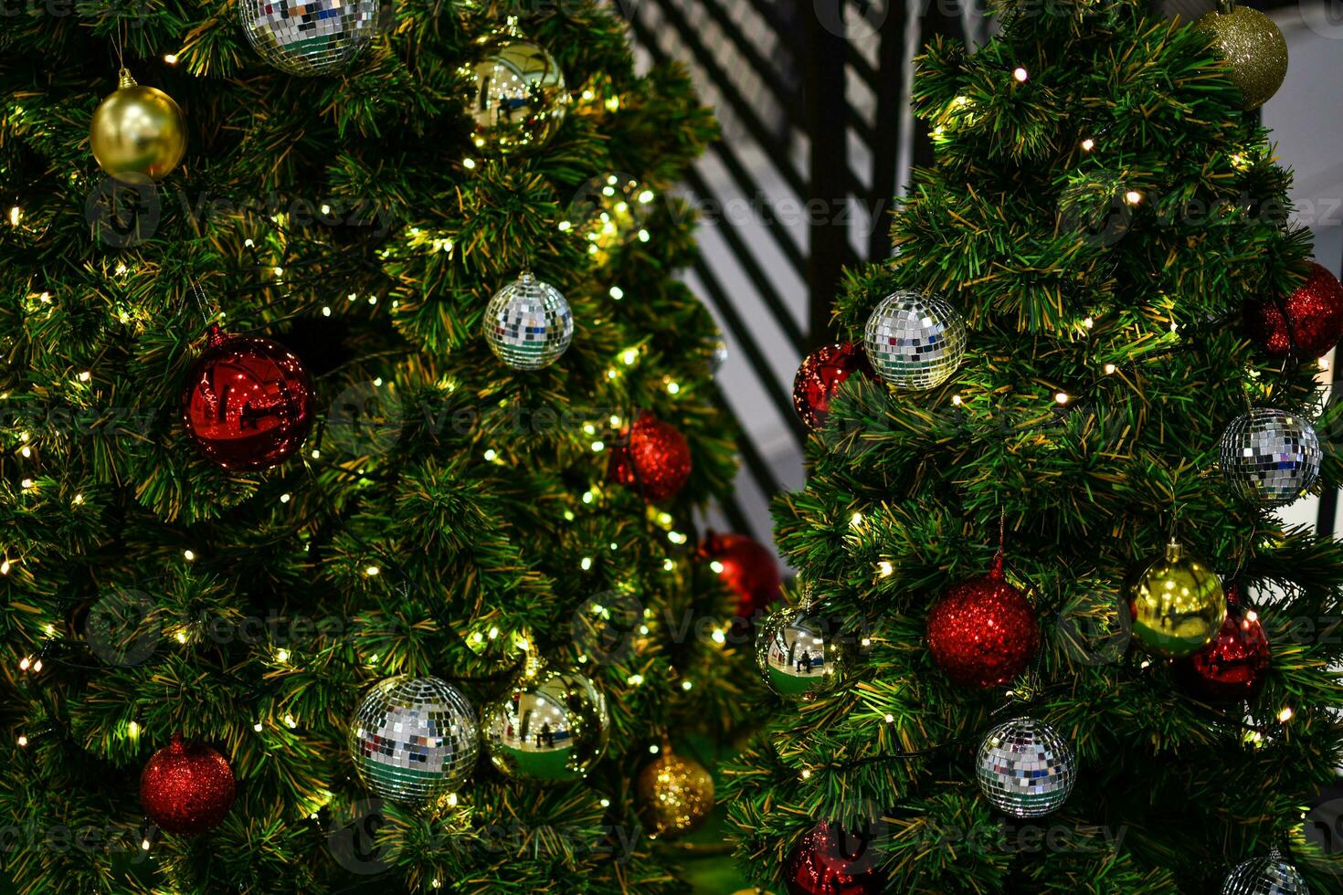 el verde Navidad árbol decorado con pequeño bombillas es un hermosa Bokeh. Navidad árbol decoración con blanco, rojo, dorado pelotas, de cerca un foto, Copiar espacio en Derecha para diseño, borroso antecedentes. foto