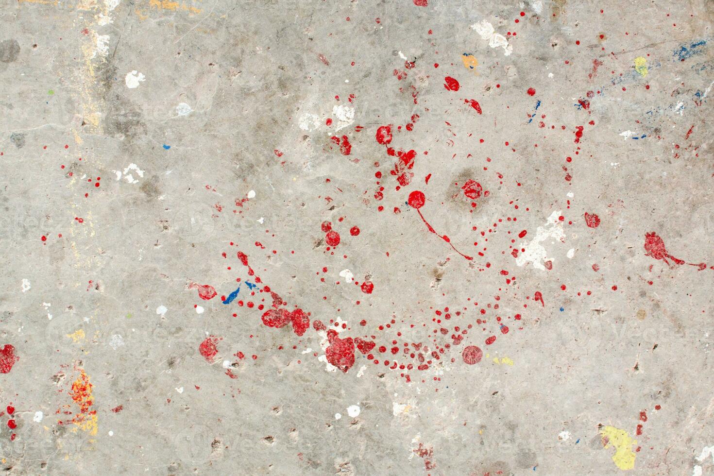 The floor is stained with several drops of various colors. Dripping paint on the concrete floor beautiful art. Droplets of red, black, and white stains on the ground. Multiple oil paint on background. photo