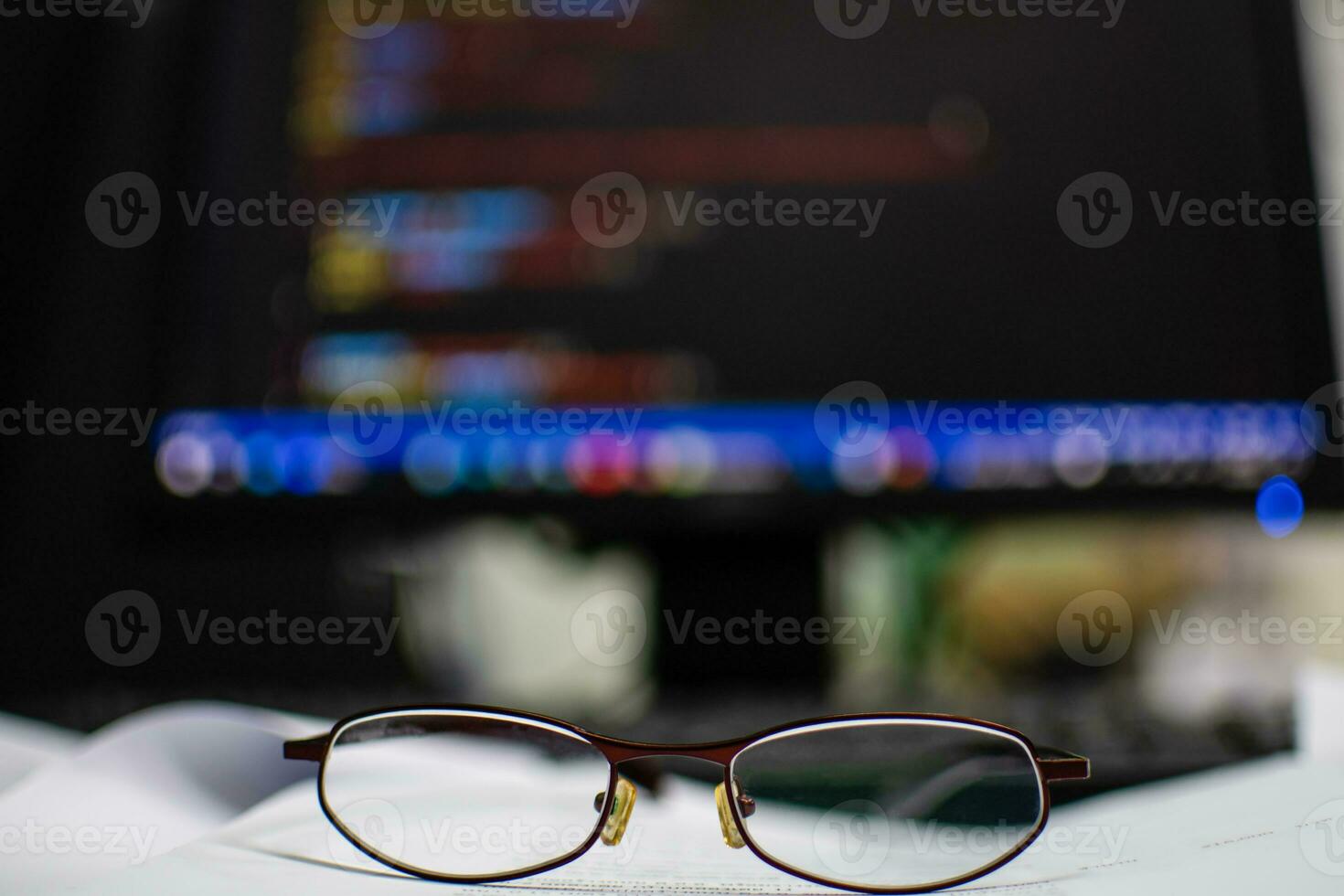 Programmer's glasses put on the document to relax after long coding for application creation and website design for businesses with a focus on cybersecurity. tack closeup photo and blurred background