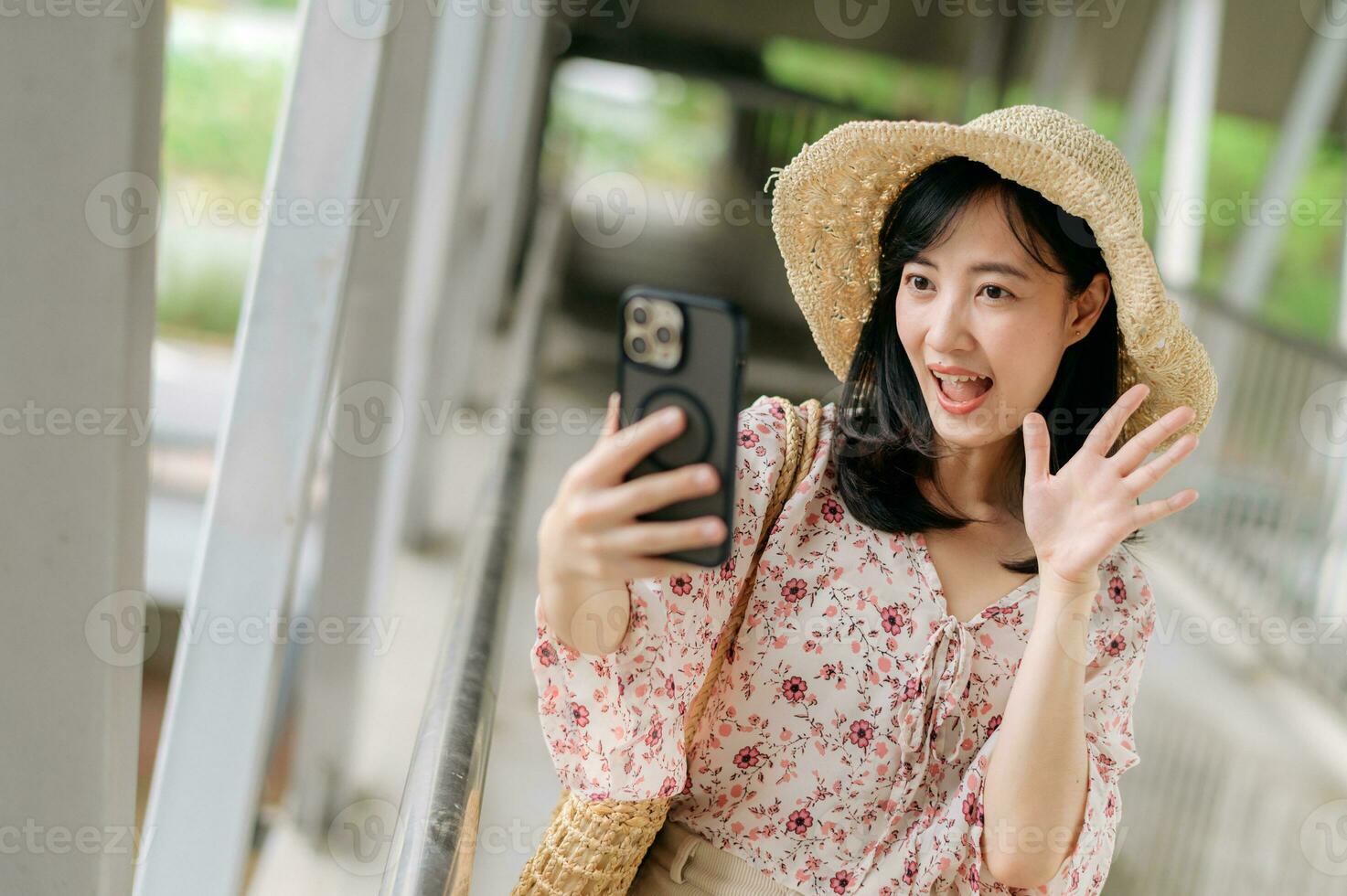 joven asiático mujer viajero con Costura cesta selfie con móvil teléfono y en pie en paso superior. viaje viaje estilo de vida, mundo viaje explorador o Asia verano turismo concepto. foto