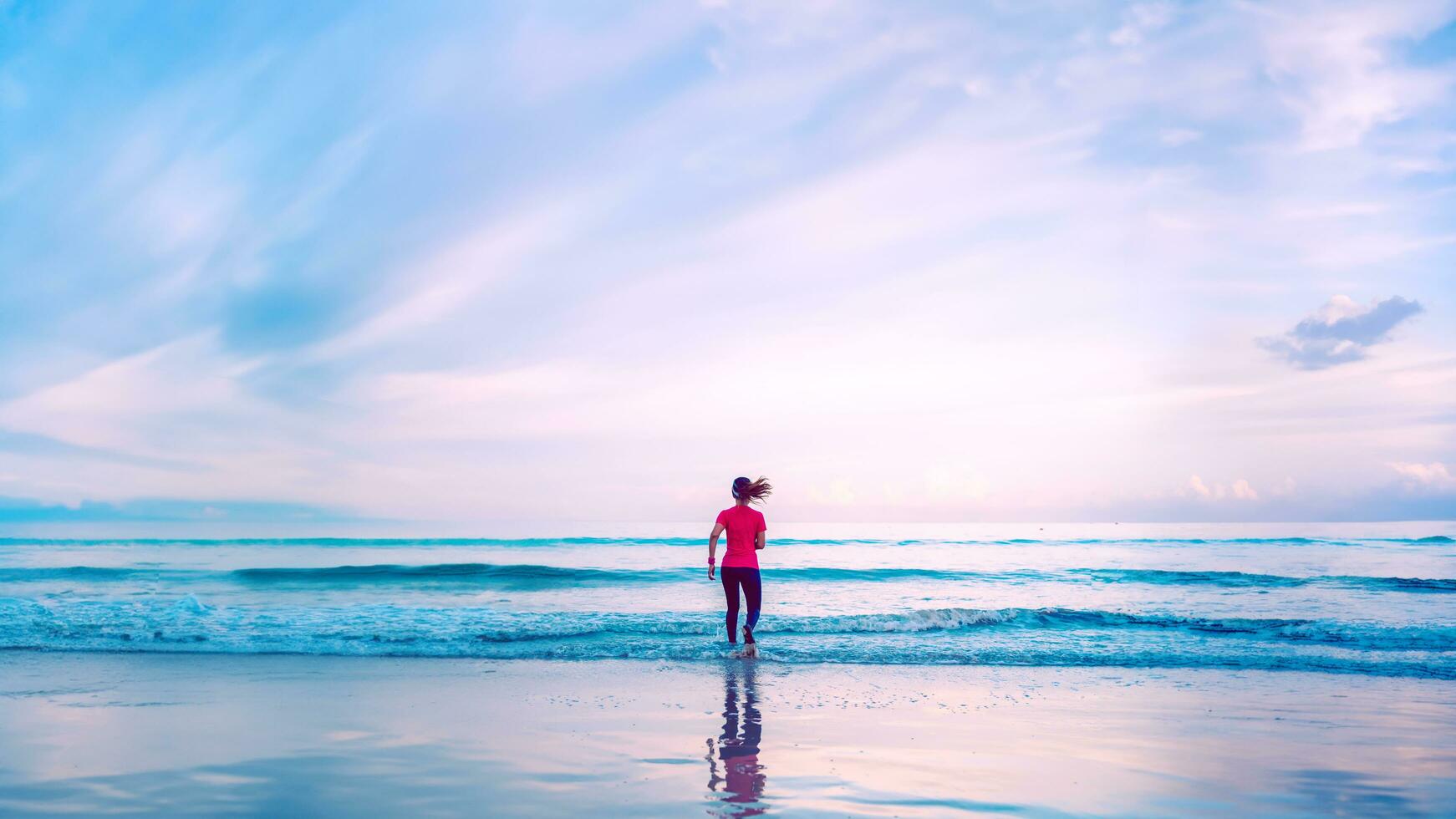 Girl running workout jogging on the beach in the morning. relax and happy with running on the sea. in summer photo