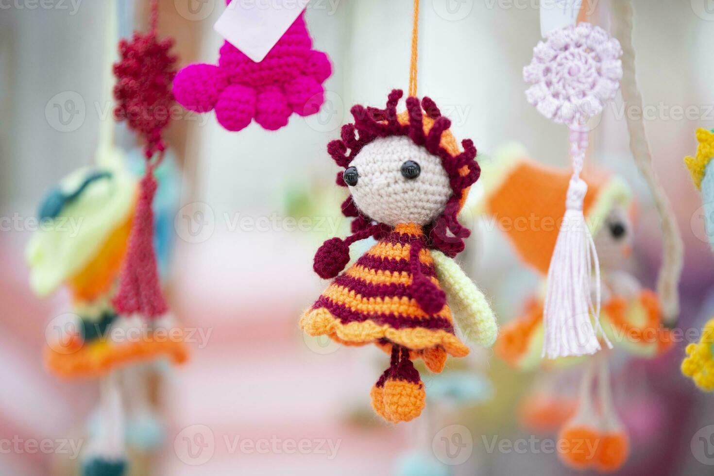 Small funny handmade knitted dolls are for sale at the craft fair. photo