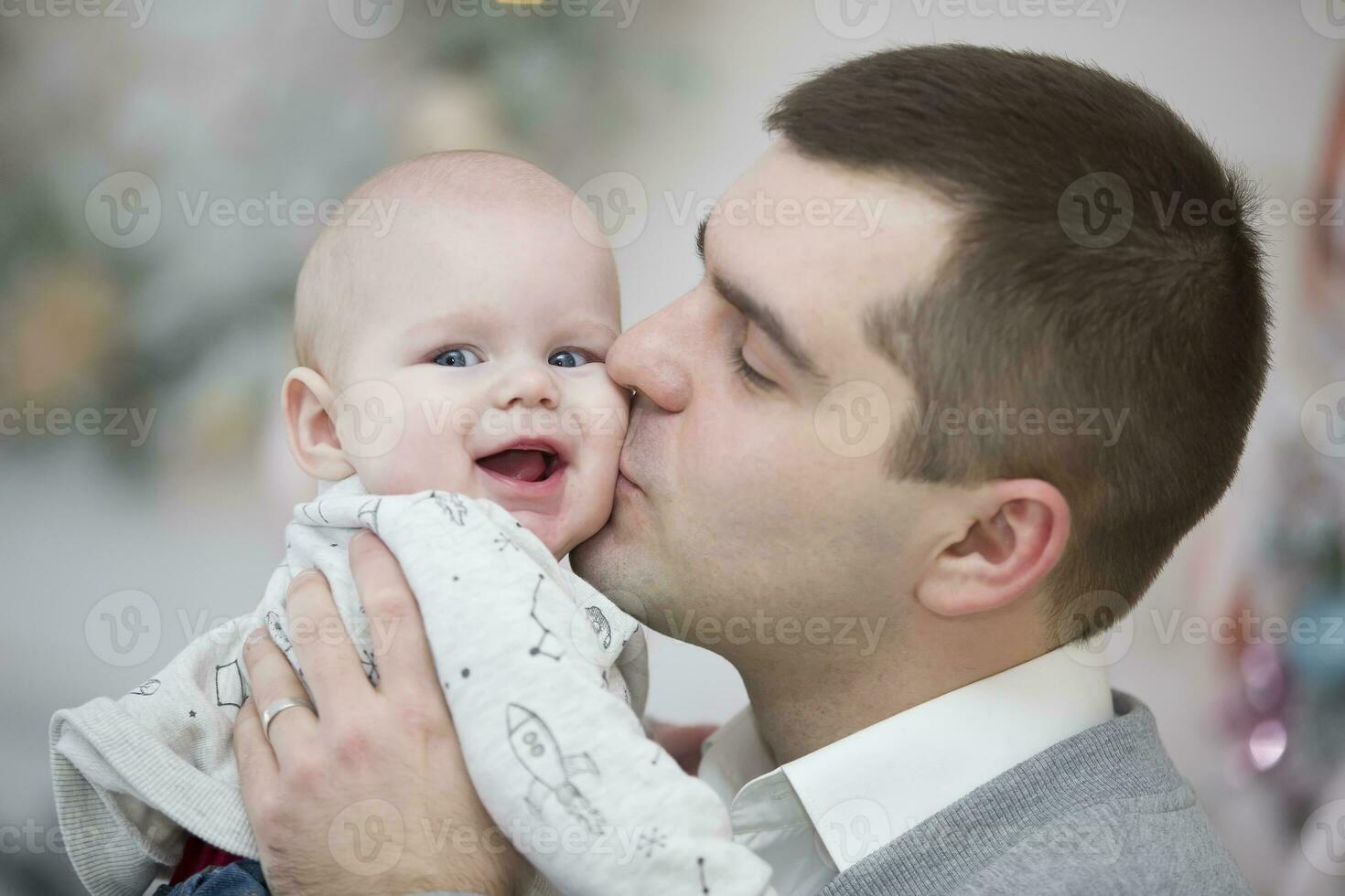 Dad kisses a happy baby photo