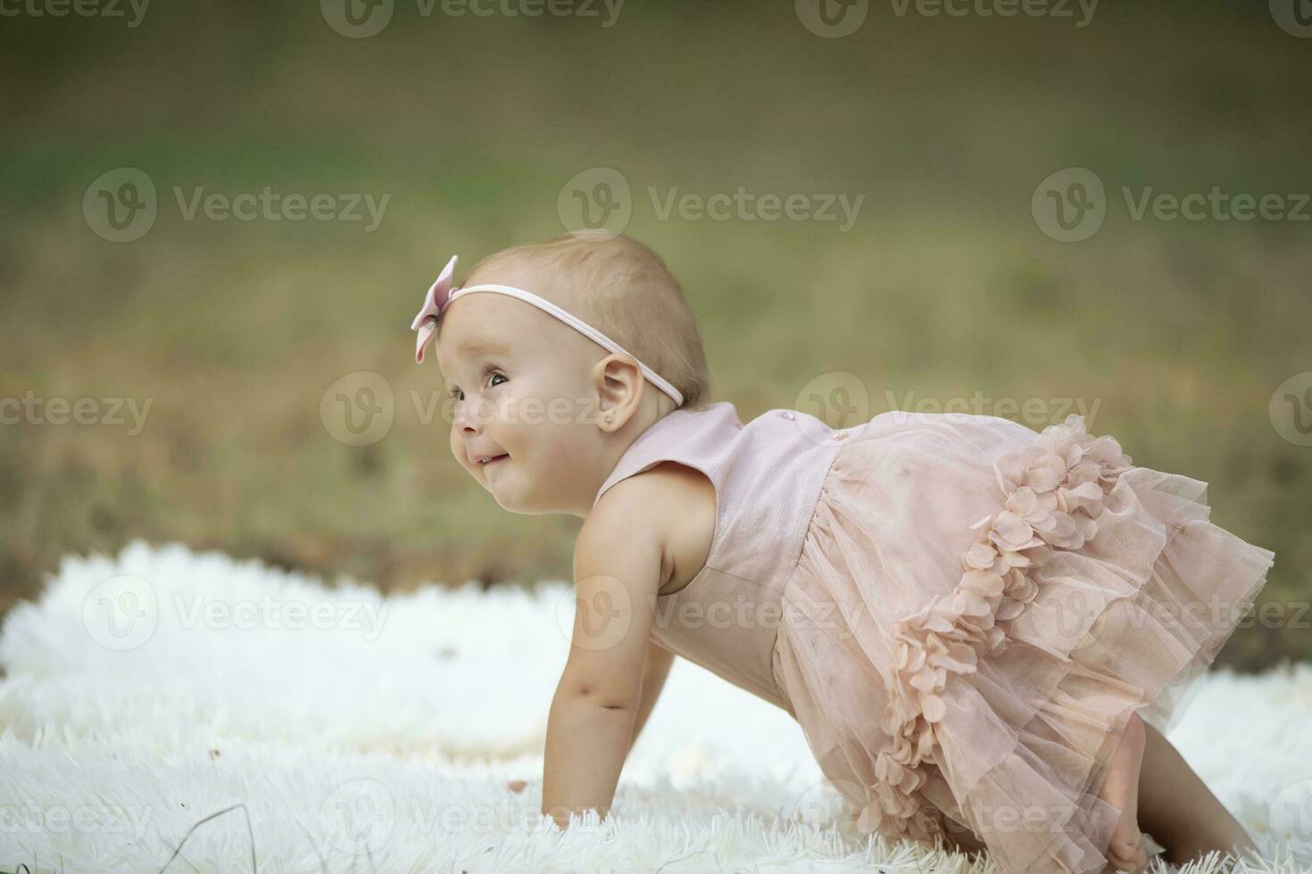 Funny little girl on a walk in a summer park. One year old child. Sweet baby. photo