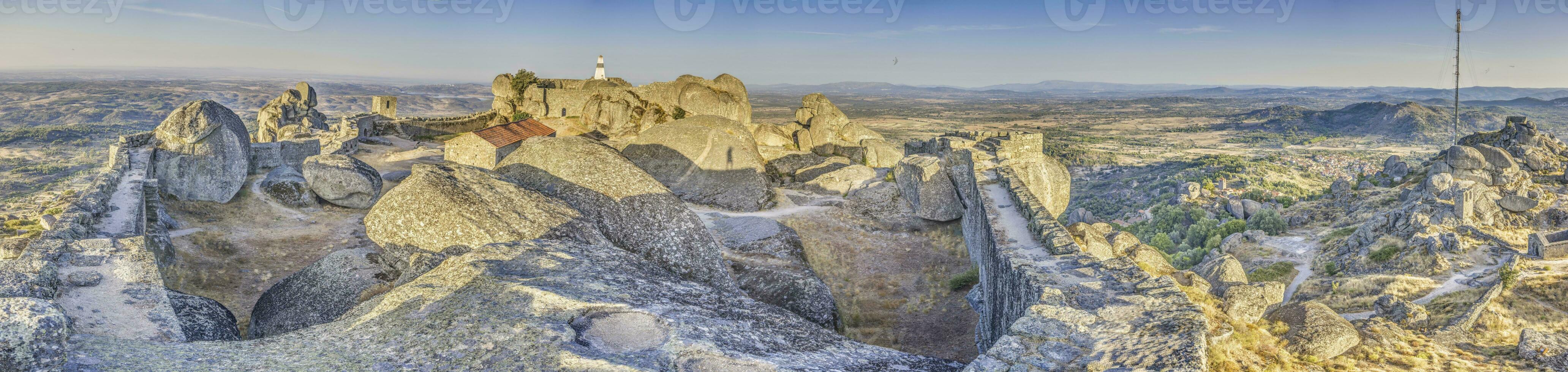 Panoramic image of the fortification above the historic town of Monsanto in Portugal during sunrise photo