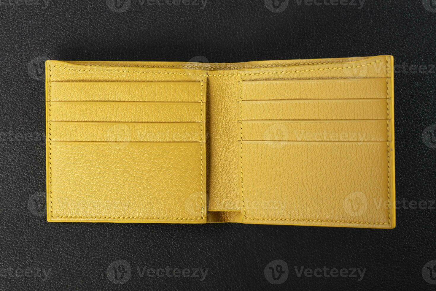 Leather products. Wallet business card holder made of yellow leather on a black background. photo