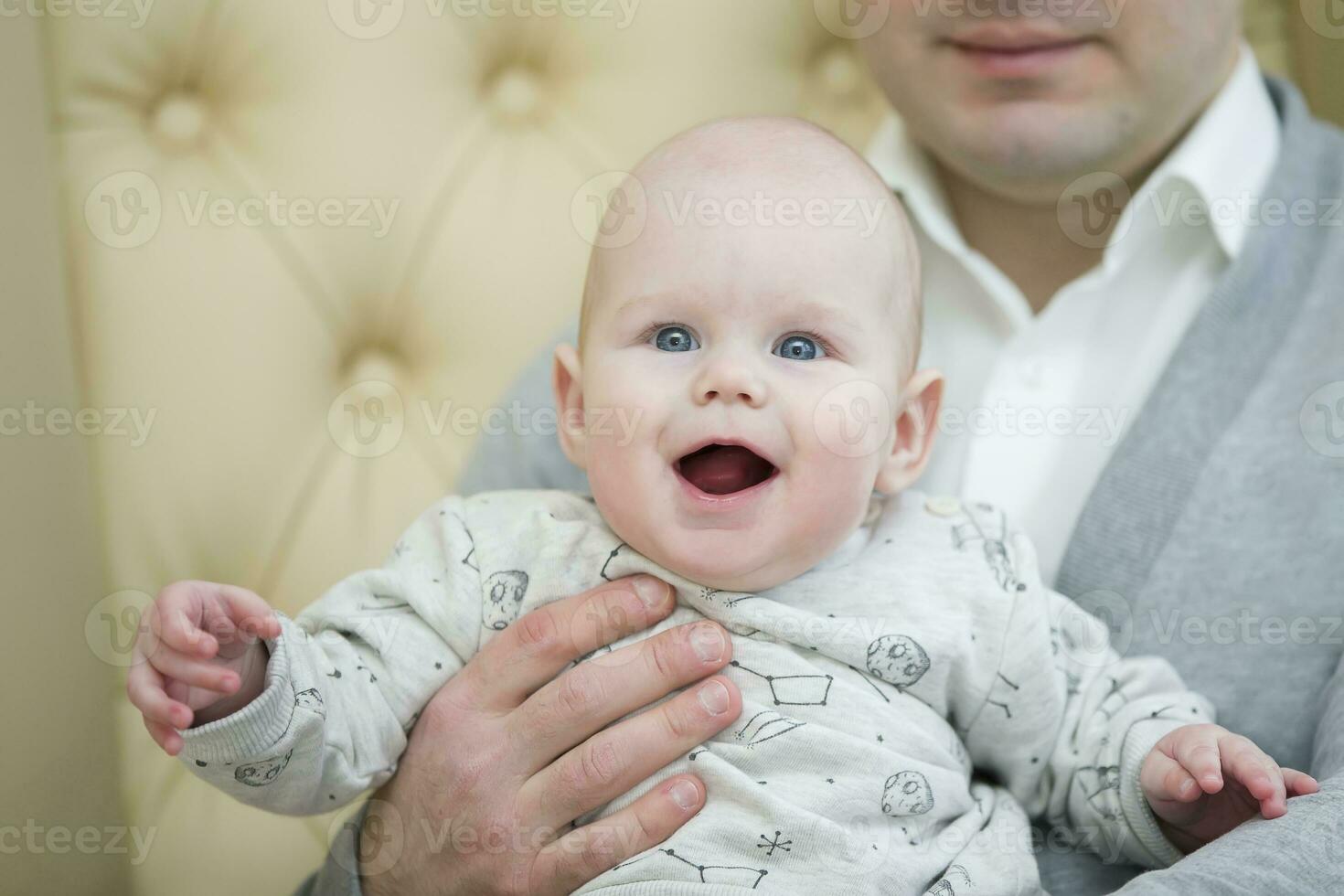 Cheerful playful baby in his father's arms. Baby and dad photo