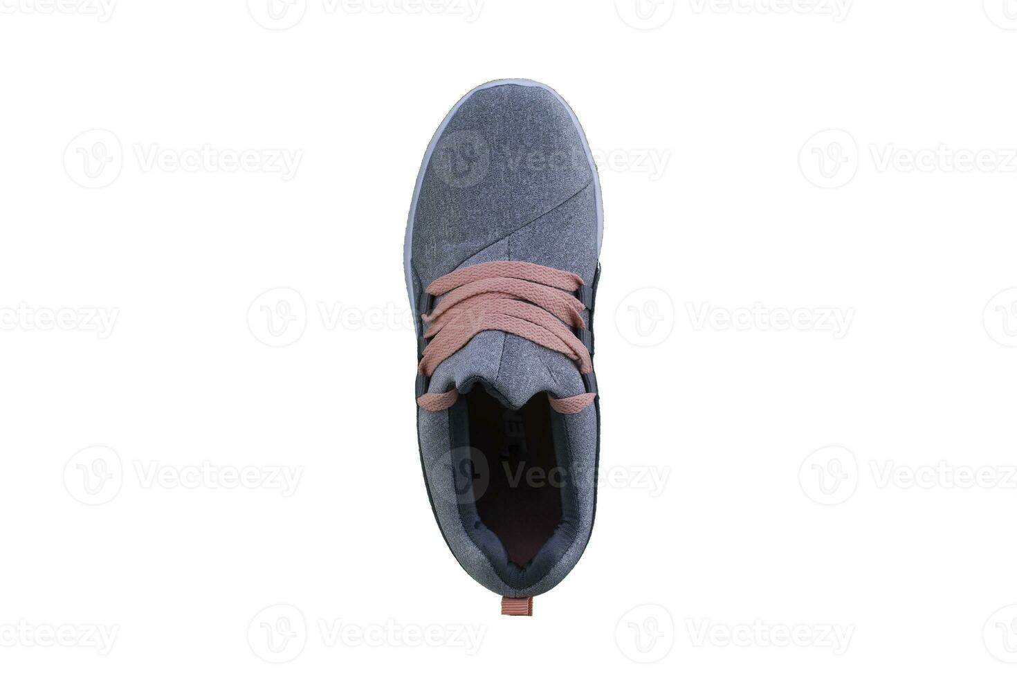 Gray sneaker with orange laces. Sport shoes on a white background top view photo